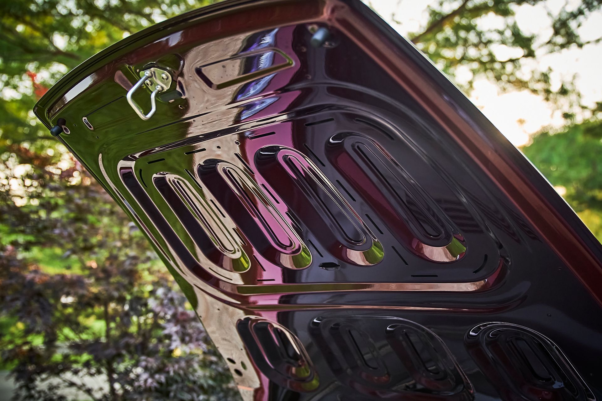 A close up of the hood of a car with the hood open.