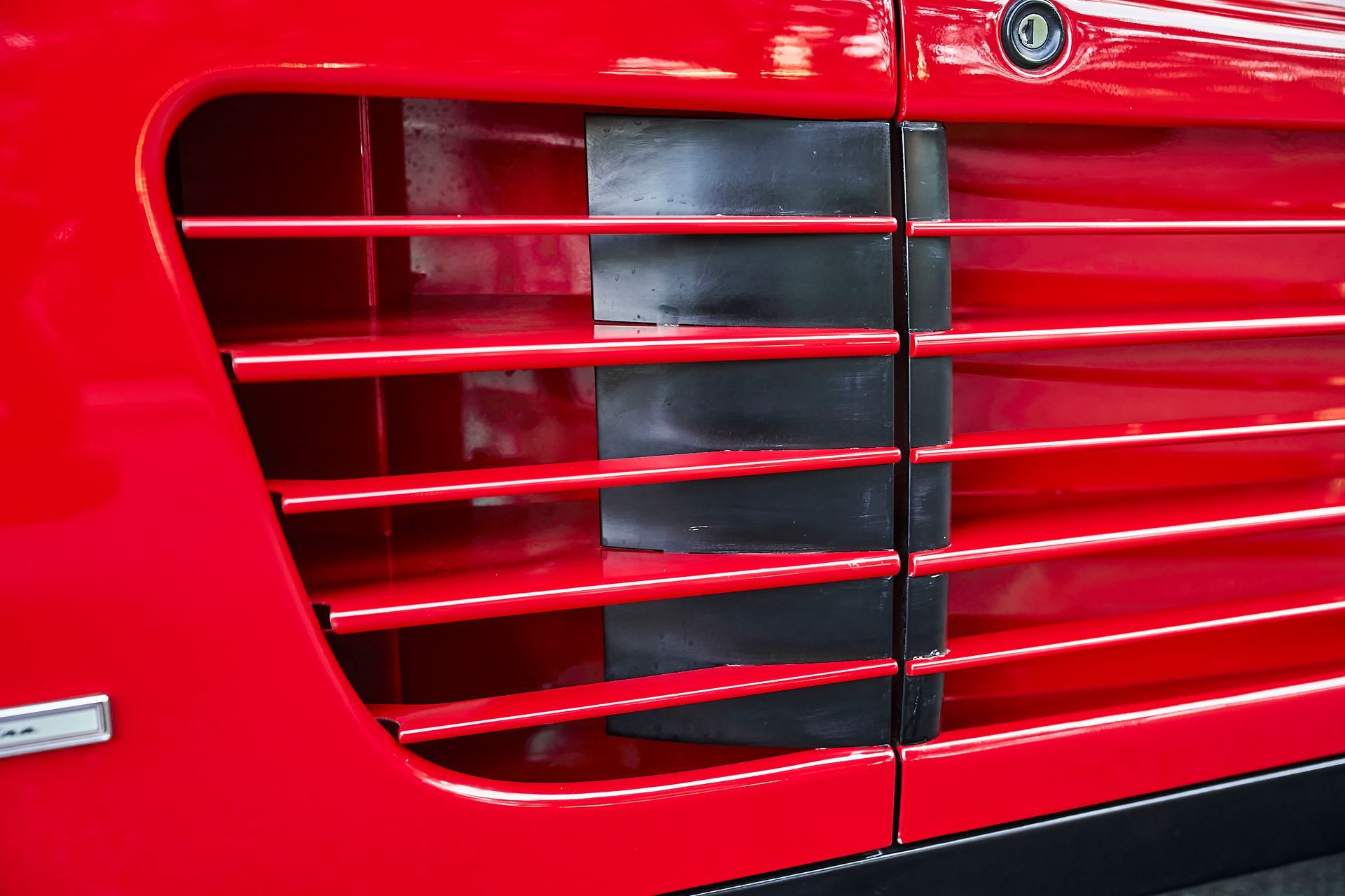 A close up of a red car with a black grille