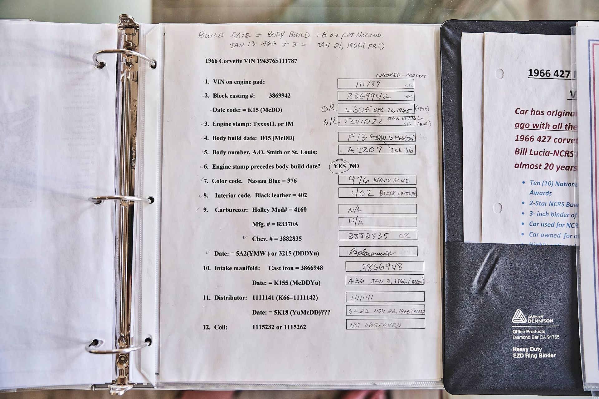A binder open to a handwritten list of items with spaces for details, likely an organizational tool. A second sheet is visible next to it.