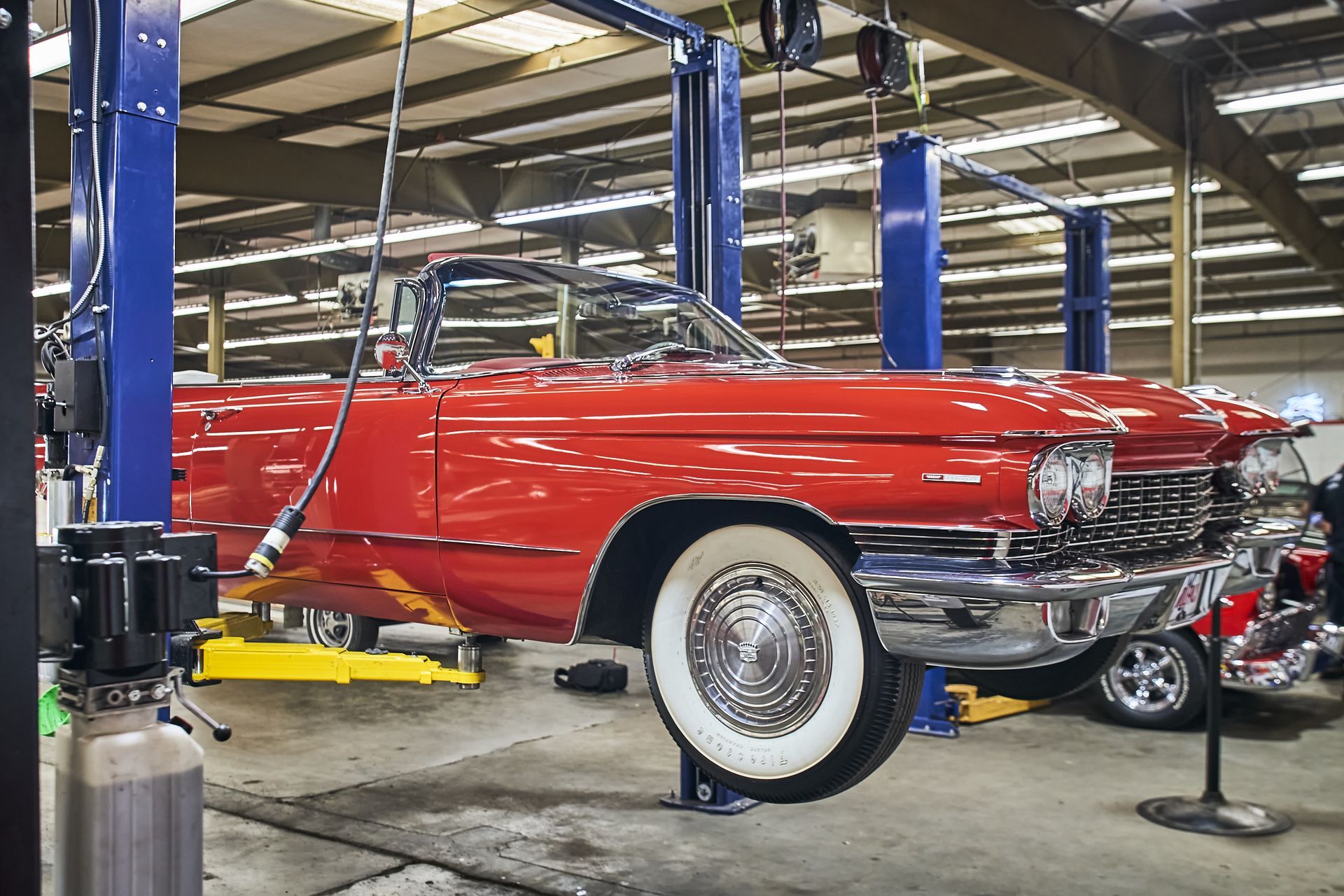 A red car is on a lift in a garage