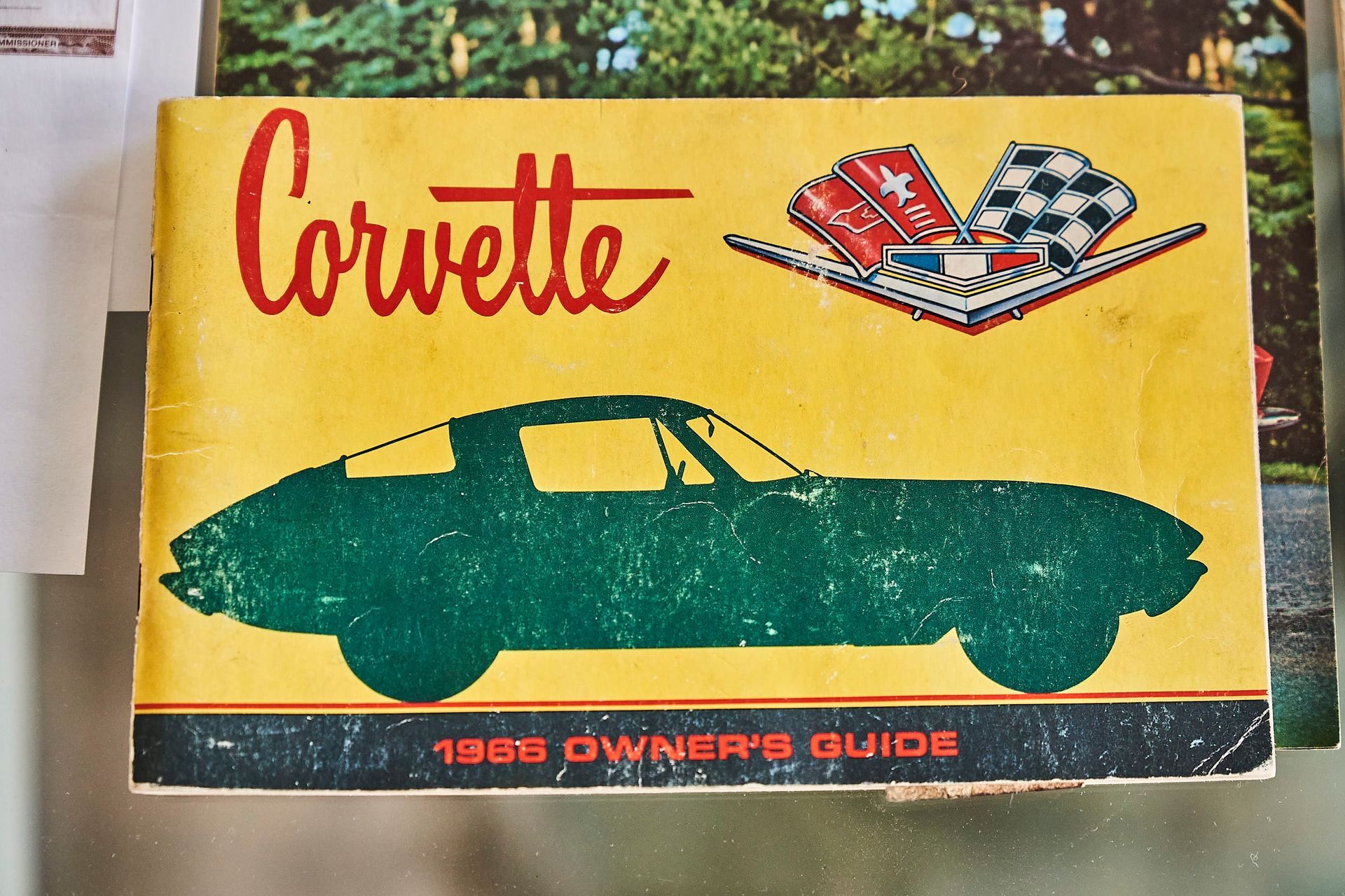Yellow 1966 Corvette Owner's Guide with green car silhouette and red text.