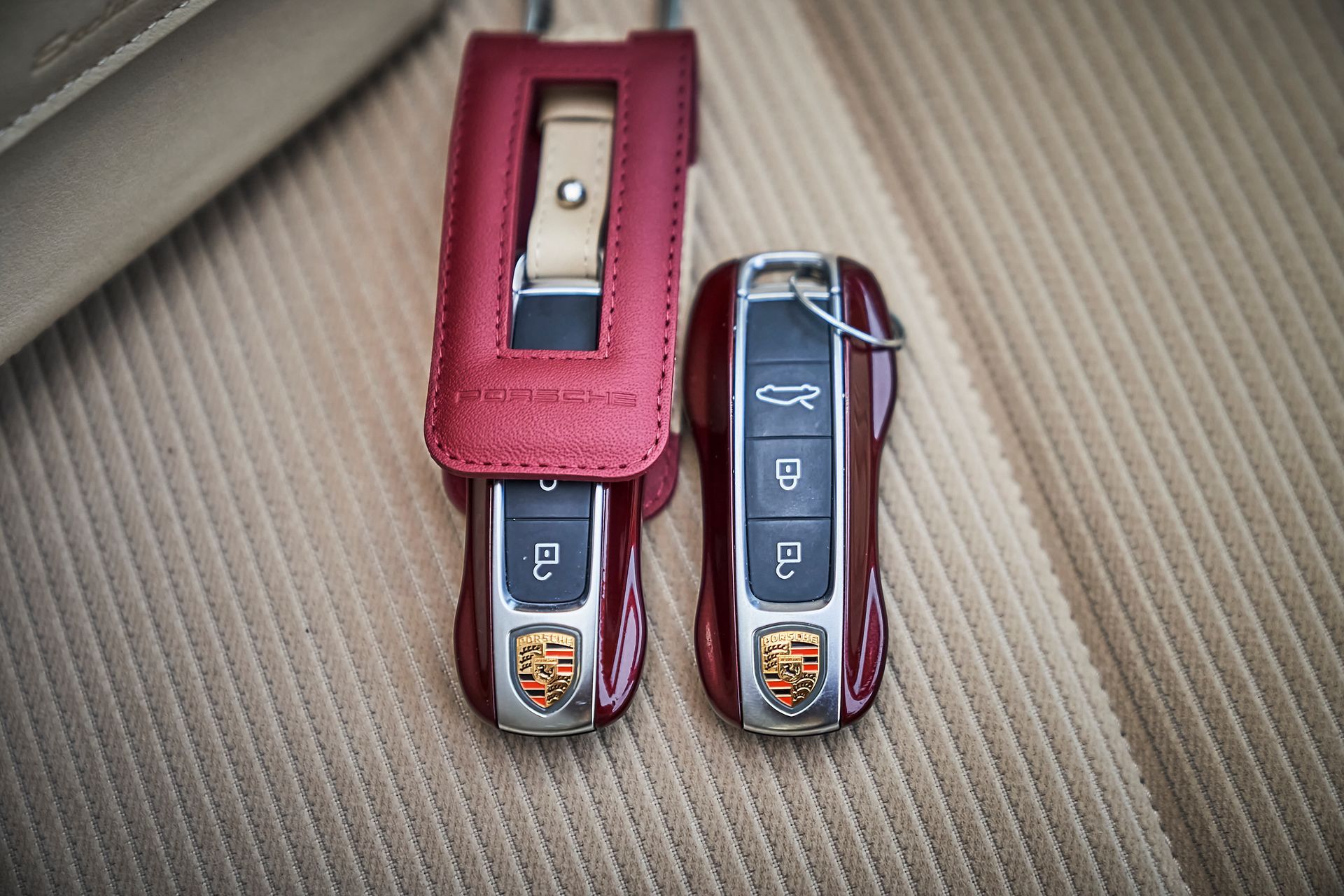 A pair of porsche remote controls in a red leather case.