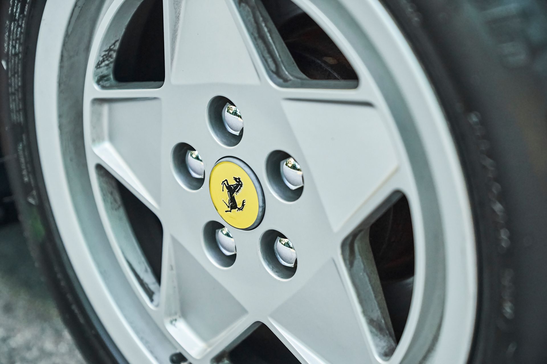 A close up of a ferrari wheel with a ferrari logo on it.