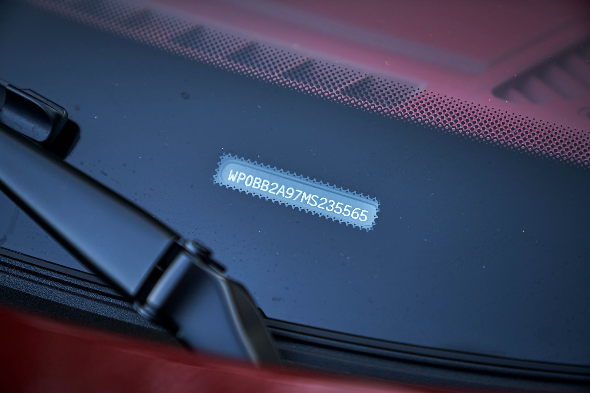 A close up of a car windshield with a license plate on it.