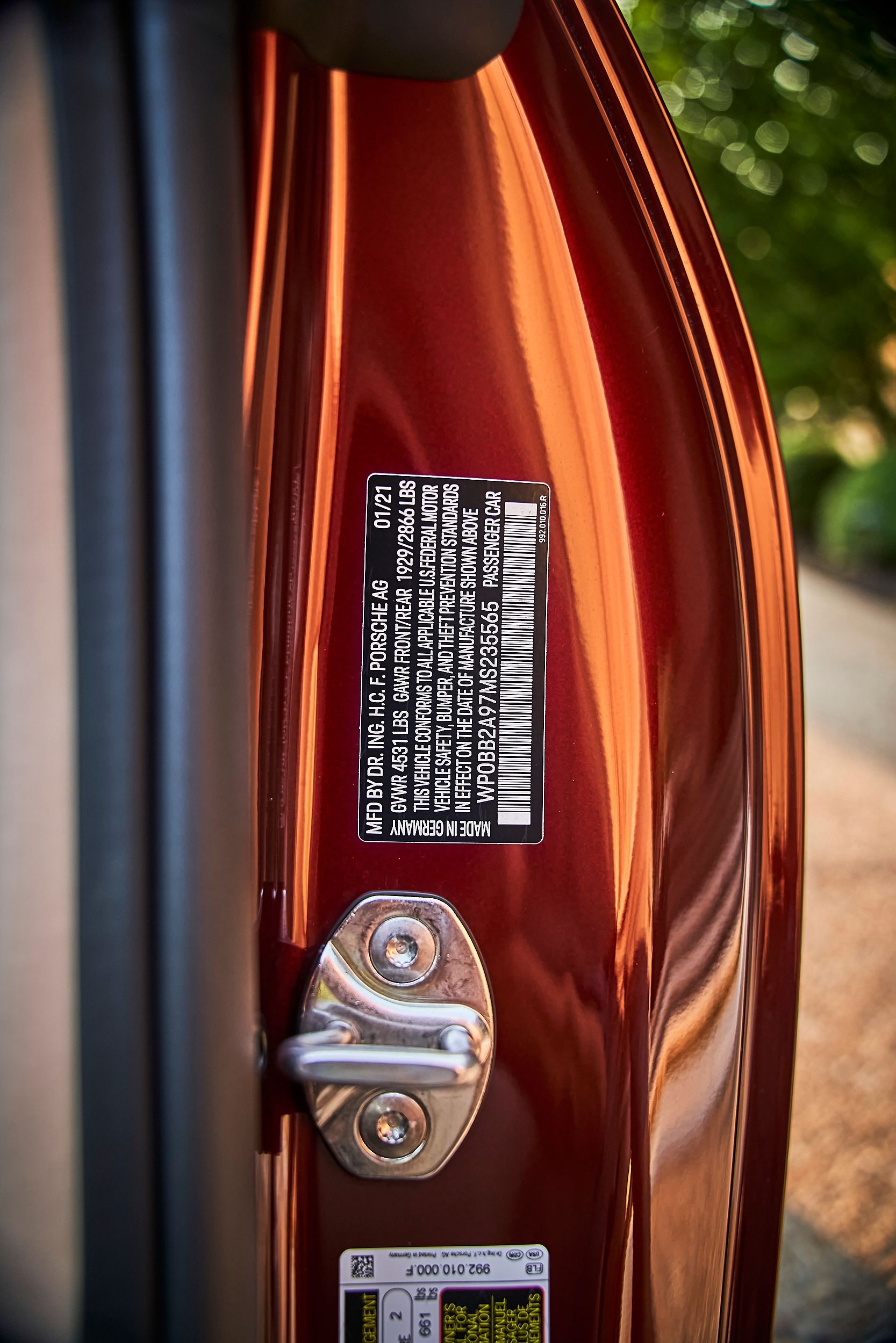 A close up of a red car door with a sticker on it