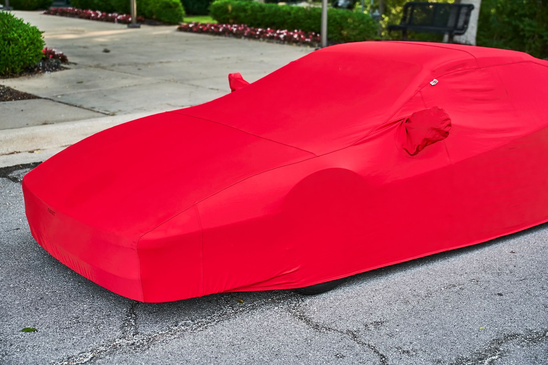 A red car cover is sitting on the side of the road.