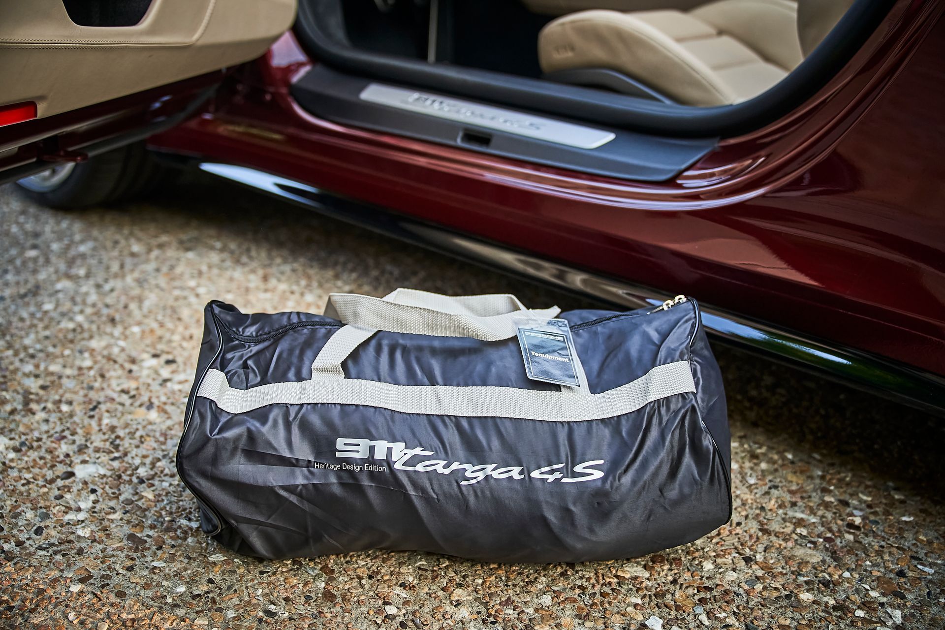 A bag with the word targa on it is sitting next to a car