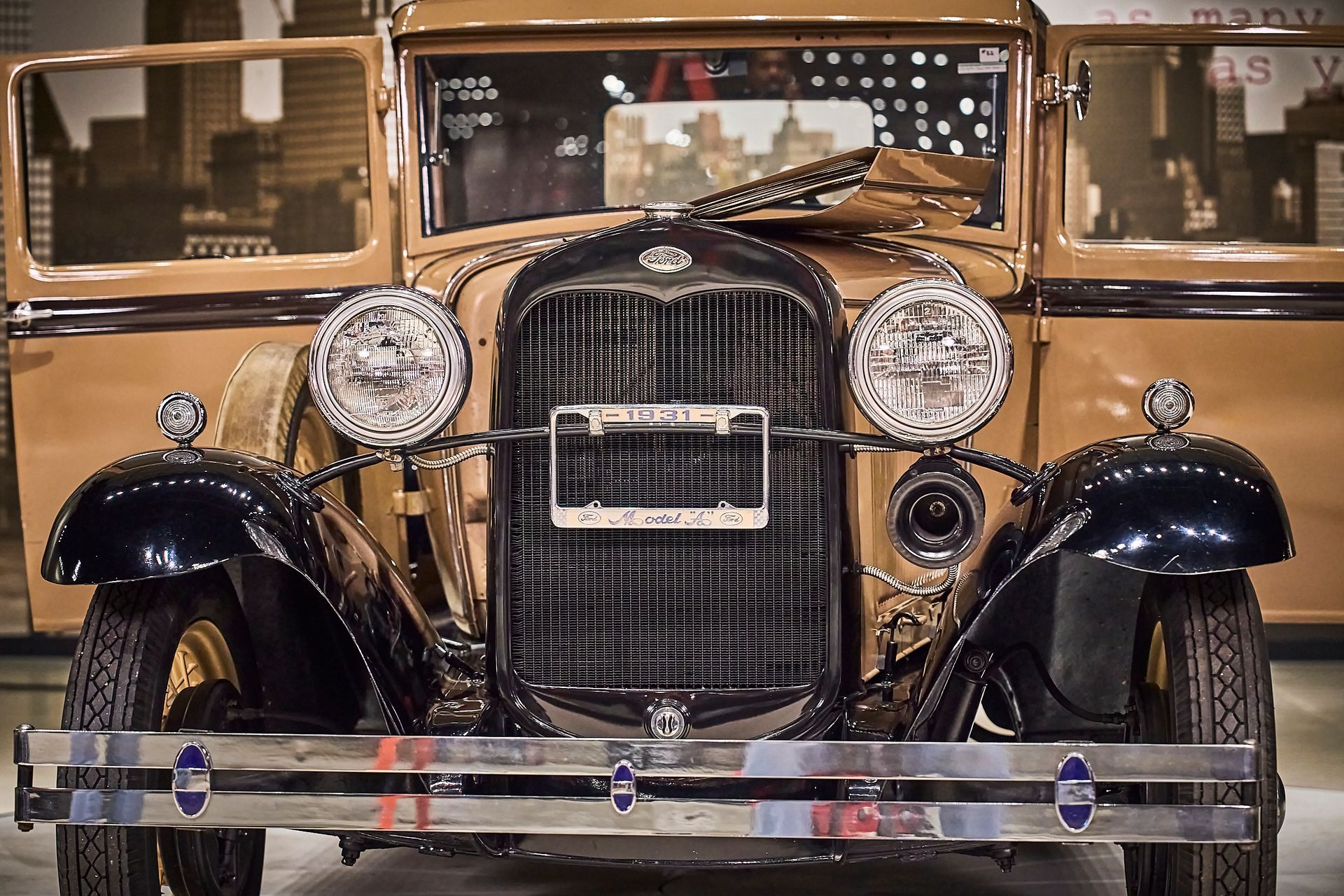 An old car with the doors open is parked in a garage.