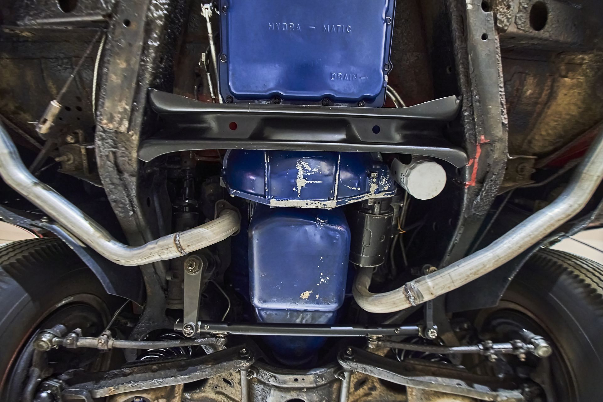 The underside of a car with a blue engine