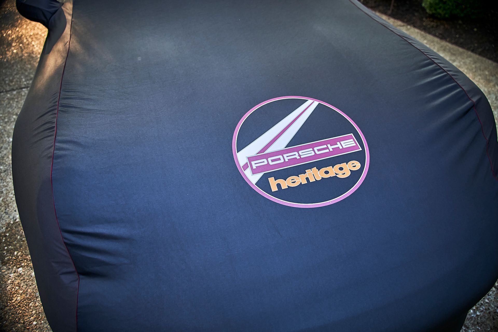 A black car cover that says porsche heritage on it