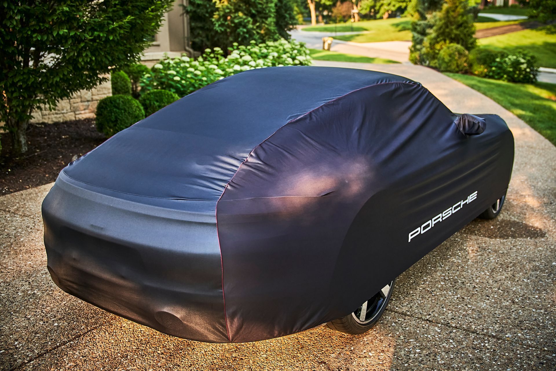A car is covered in a black car cover