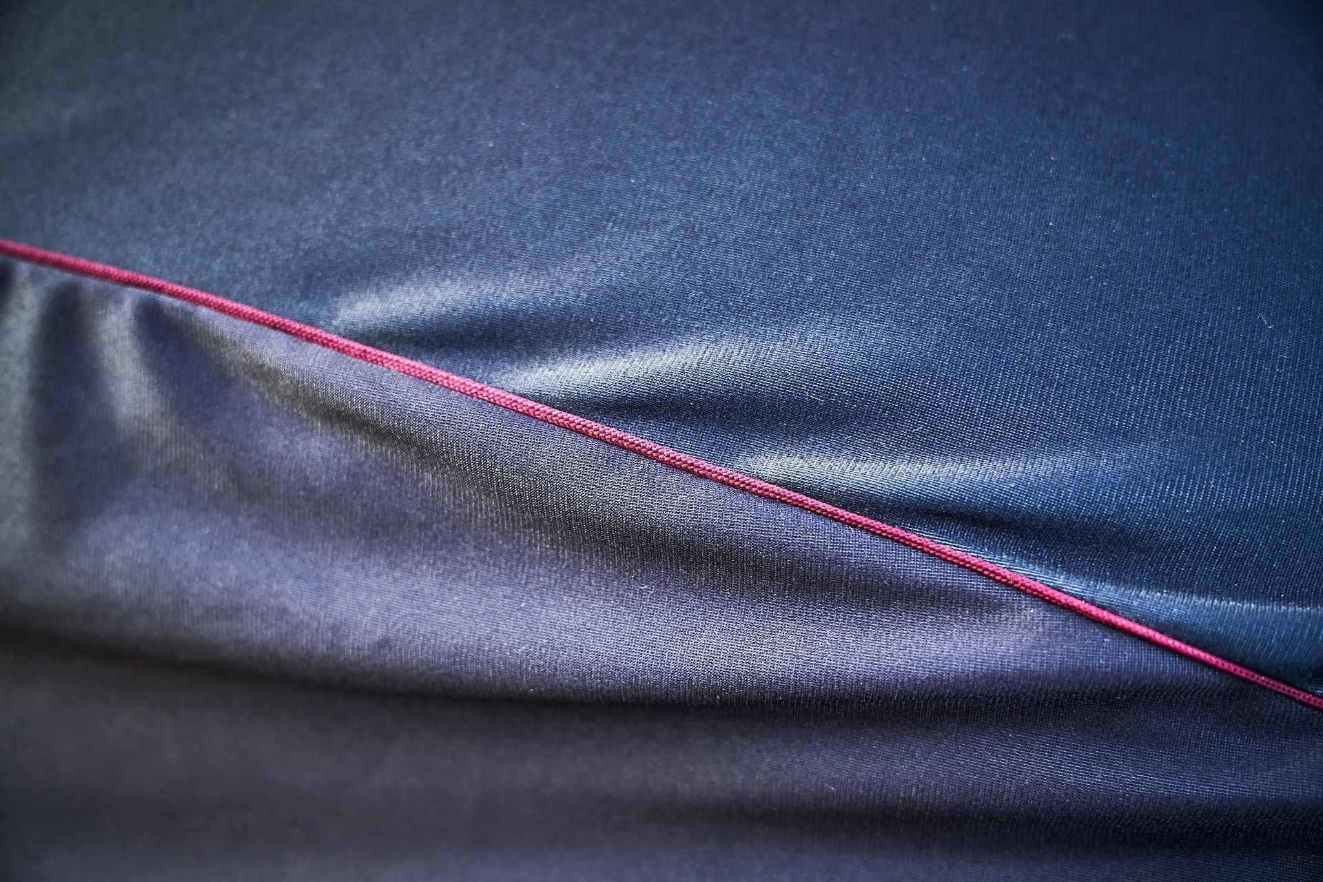 A close up of a blue shirt with a red stitching.