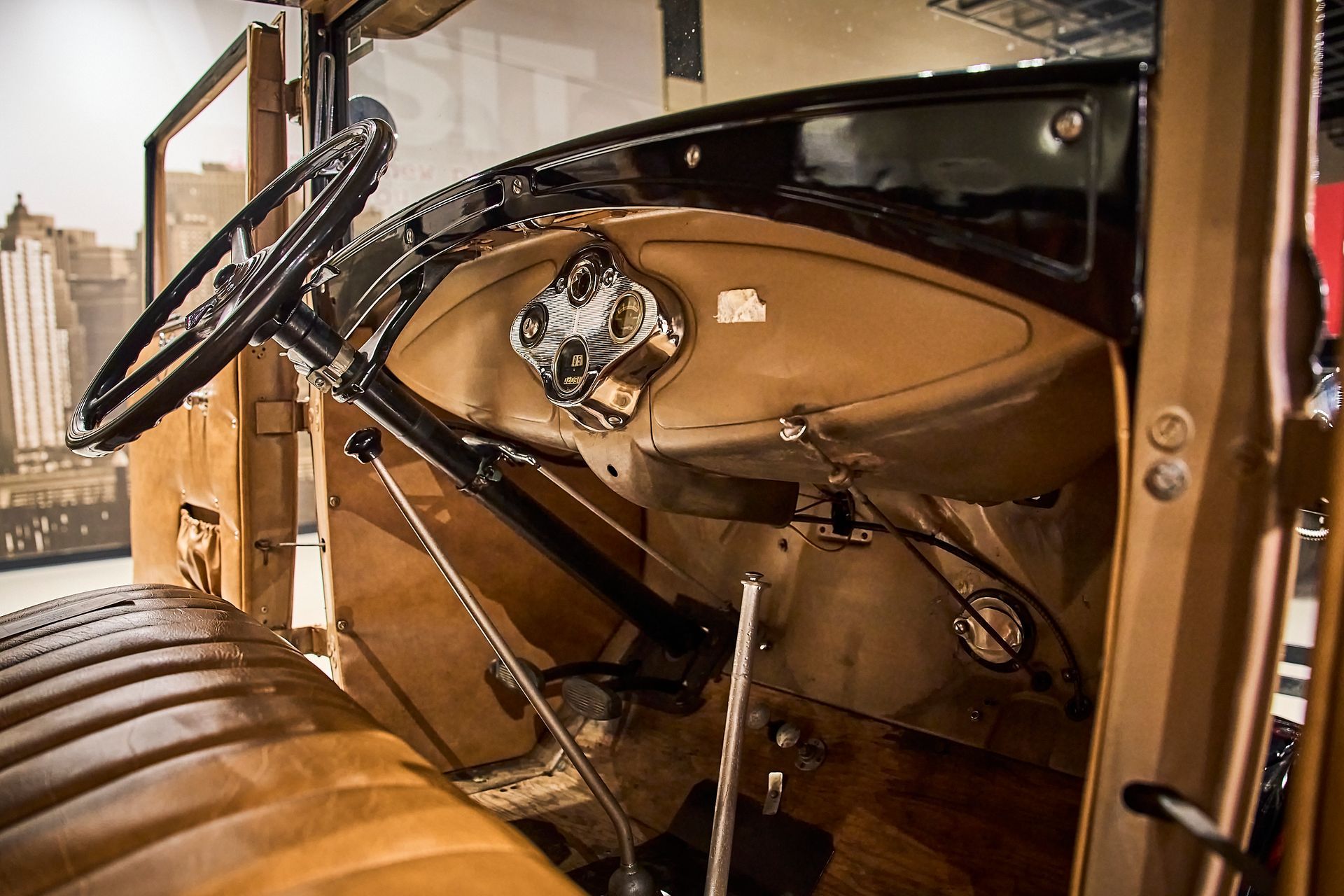 The interior of an old car with a steering wheel and dashboard.