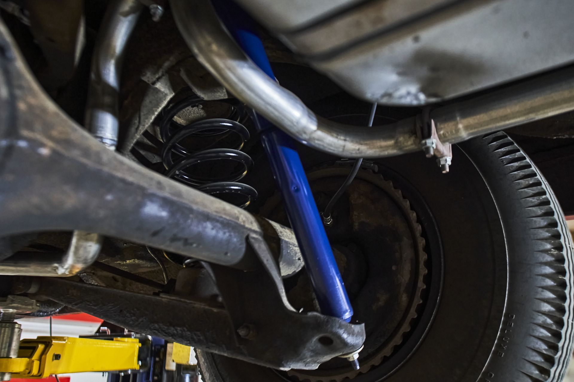 A close up of the underside of a car on a lift.