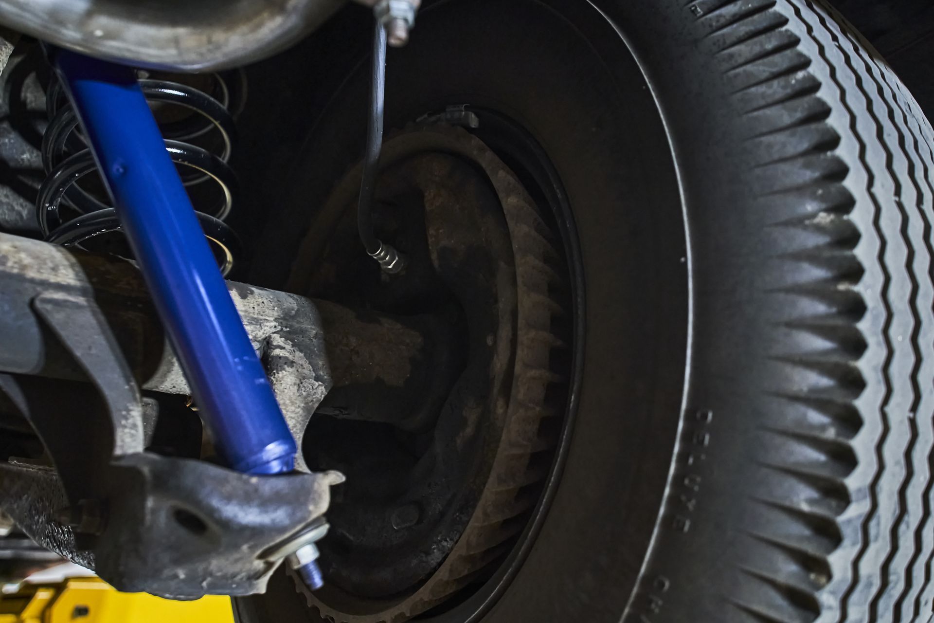 A close up of a car 's shock absorber and tire