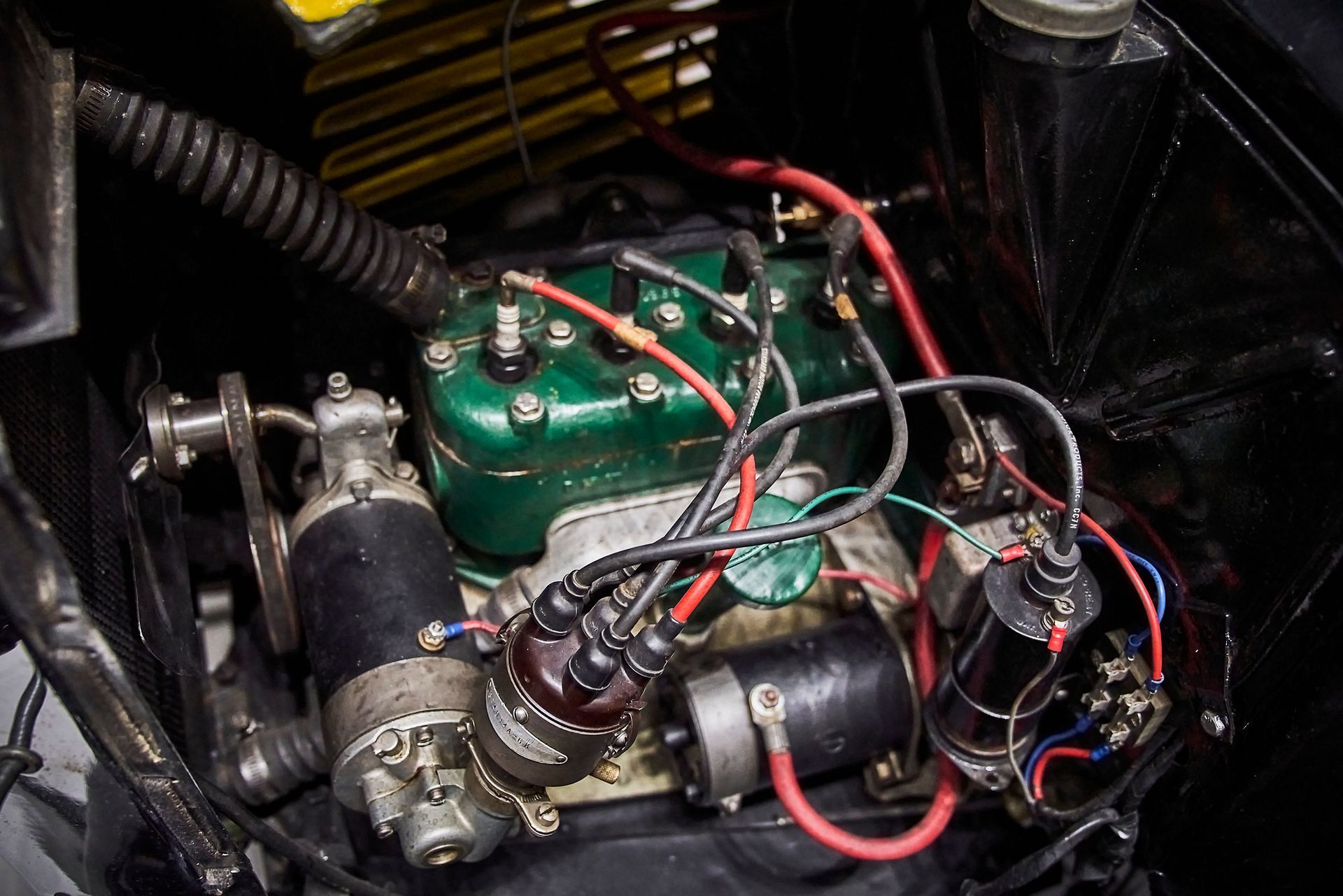 A close up of a car engine with a lot of wires coming out of it