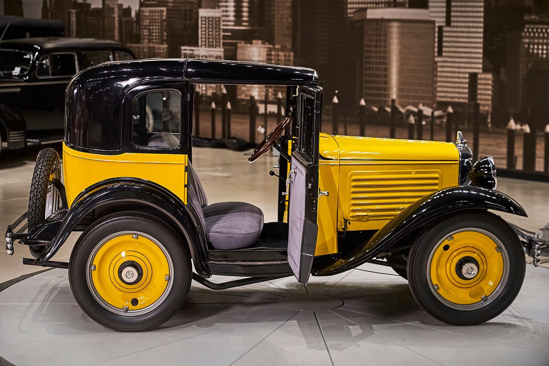 An old yellow and black car with the door open