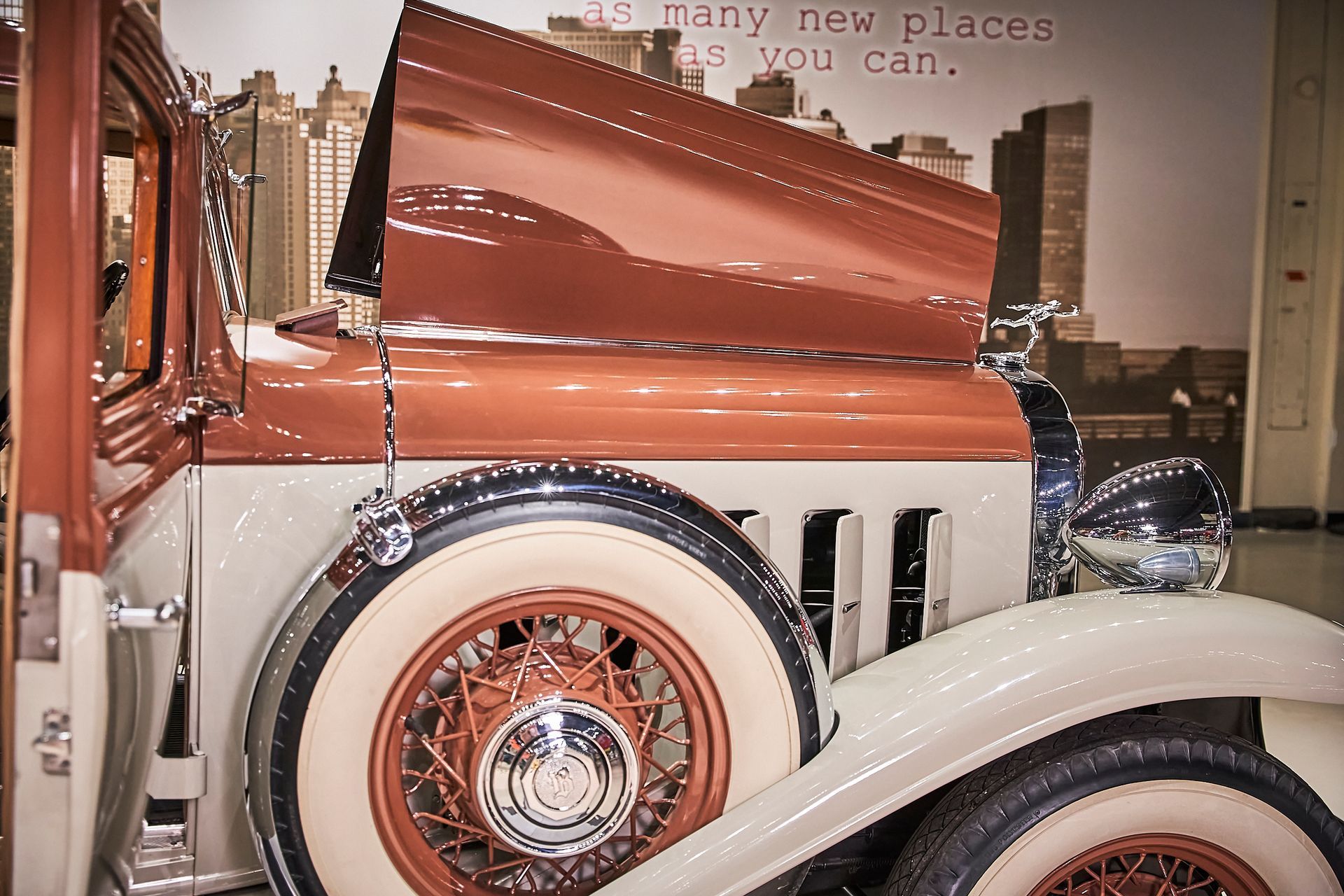 An old car with the hood up and a quote that says many new places you can