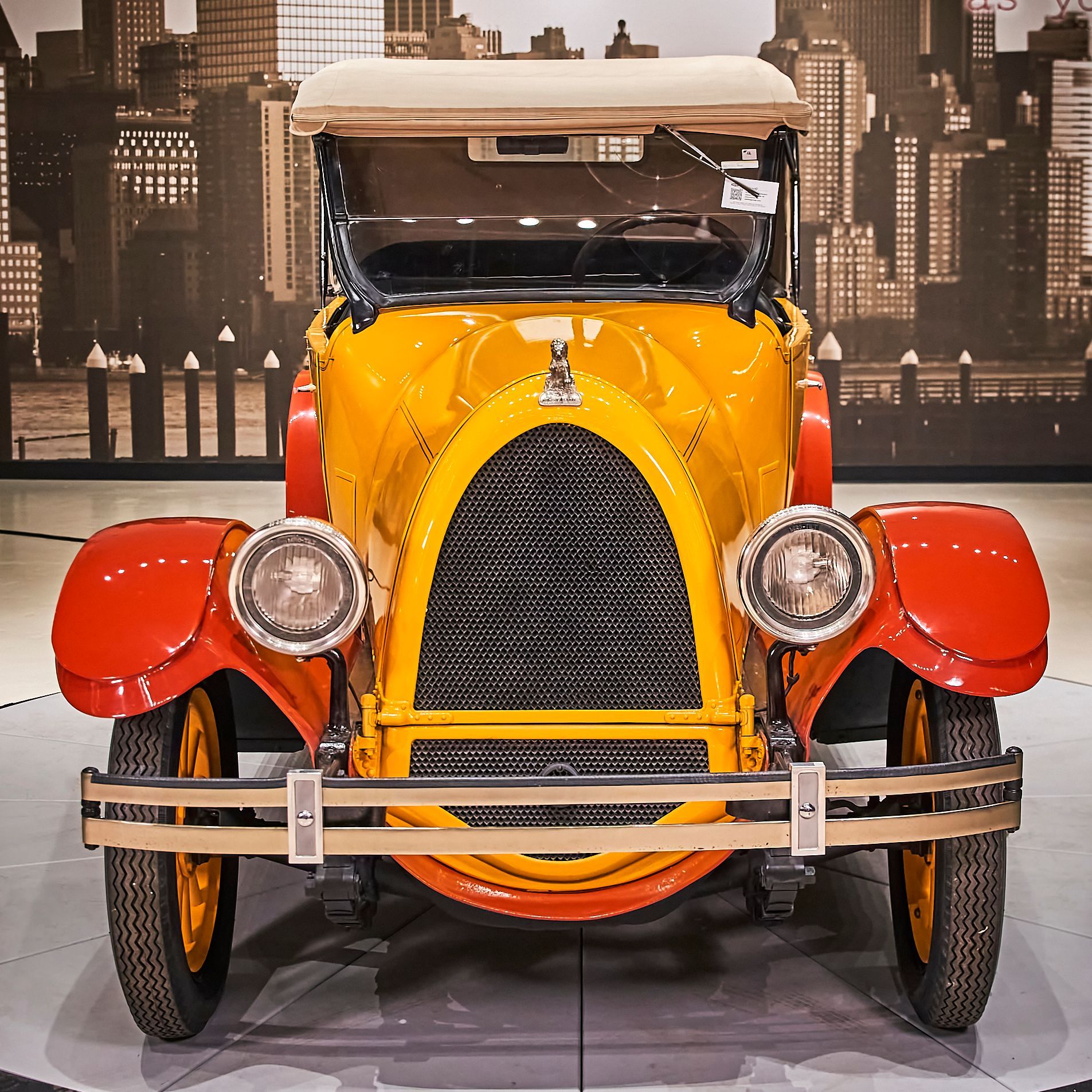 A yellow car with a red fender is on display