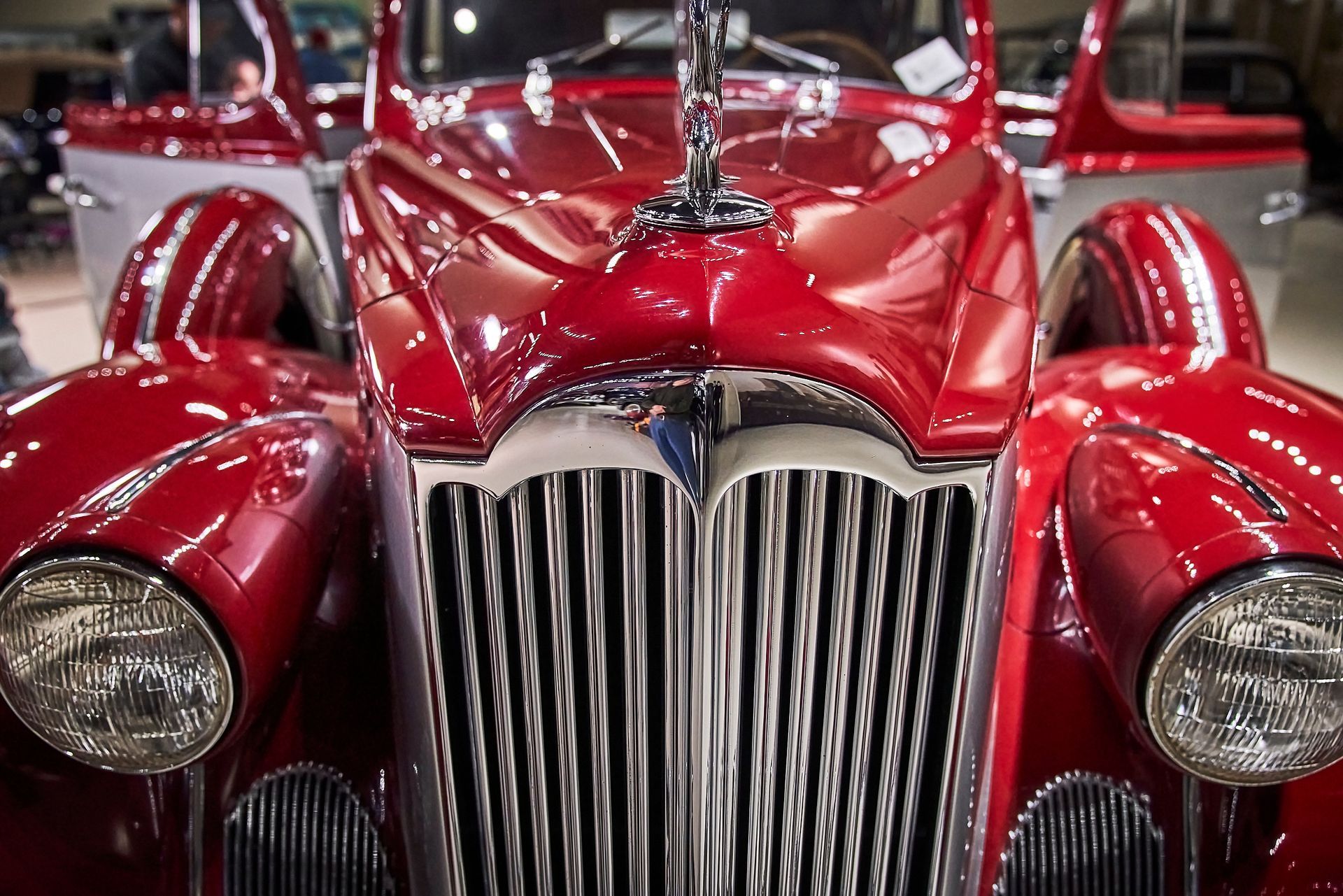 A close up of the front of an old red car