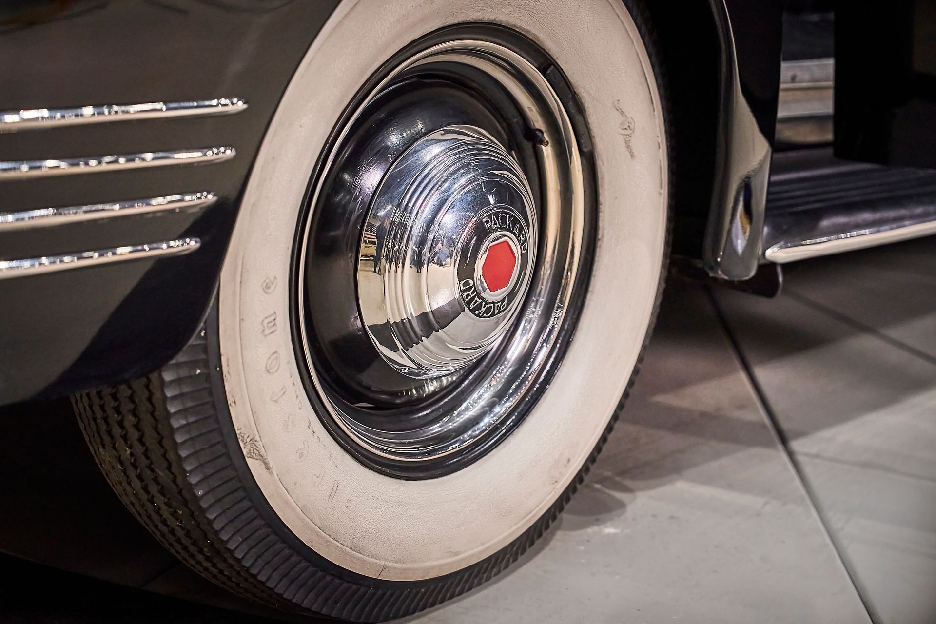 A close up of a car wheel with white tires