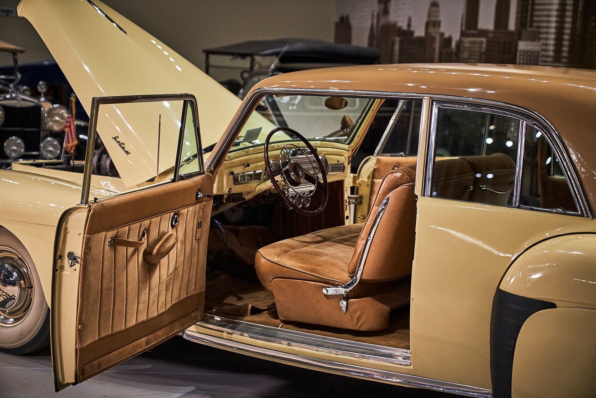 A yellow car with the door open and the hood up.