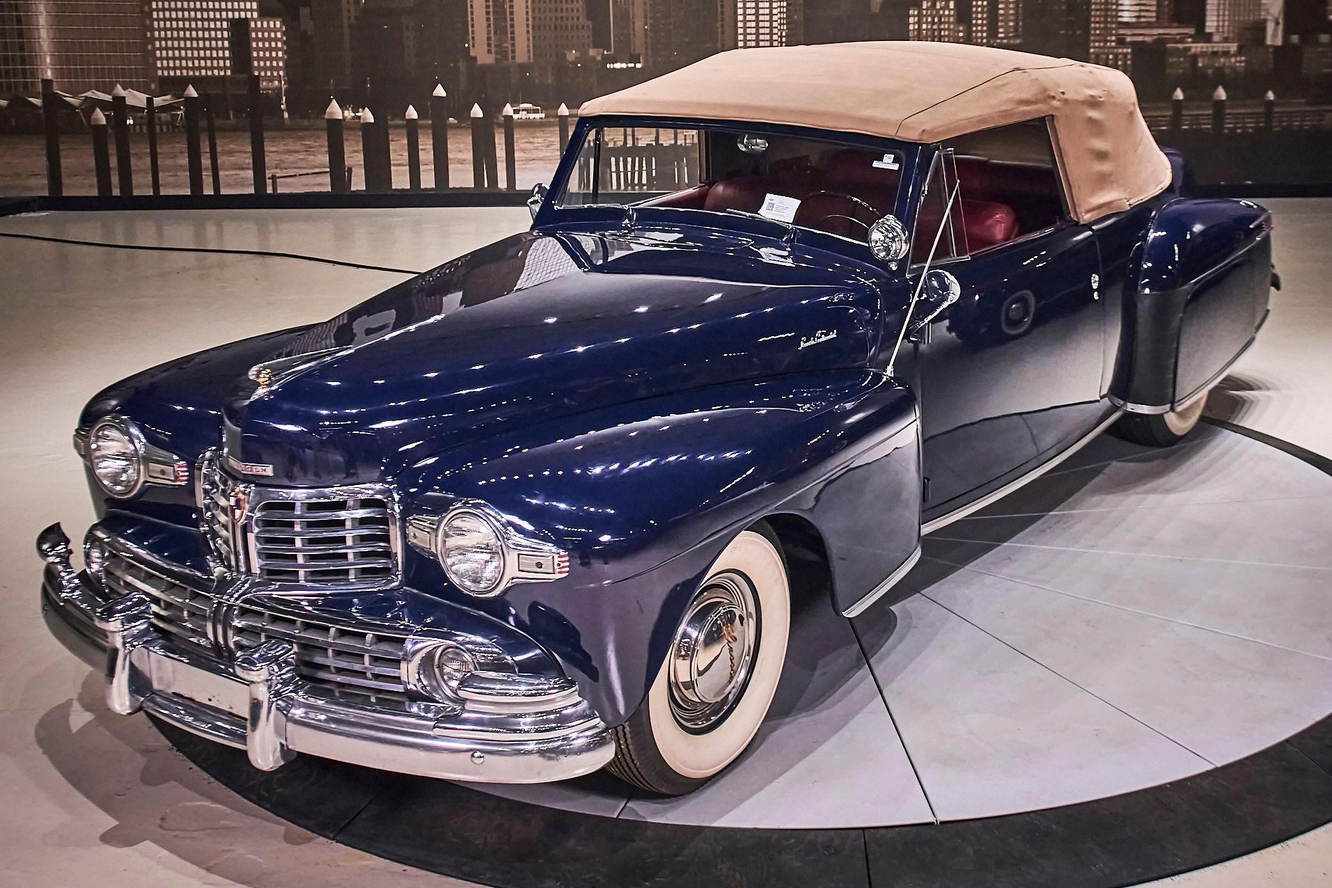 A blue car with a tan top is on display