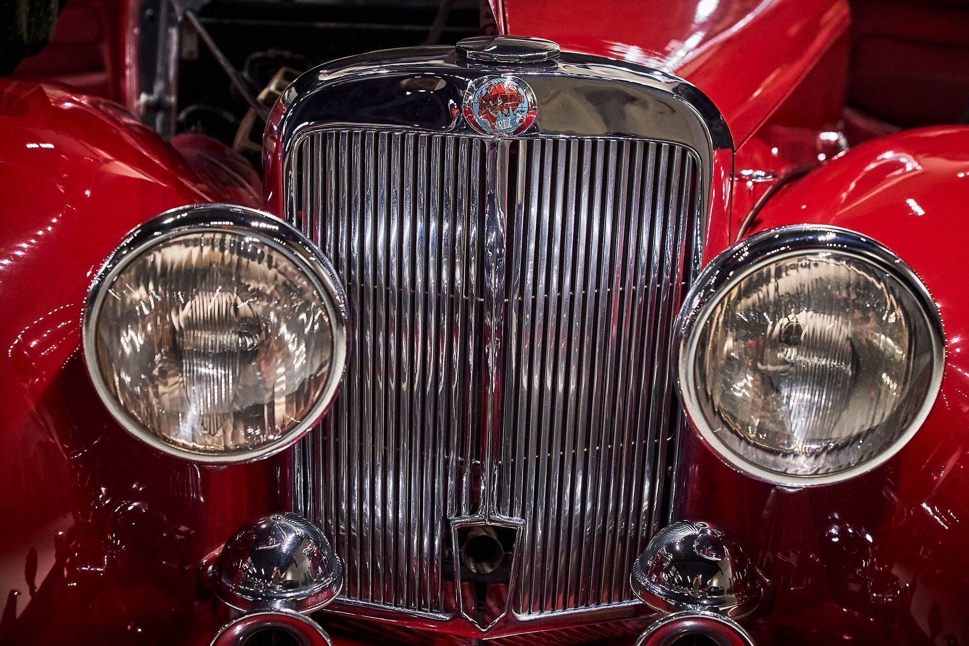 A close up of the front of an old red car