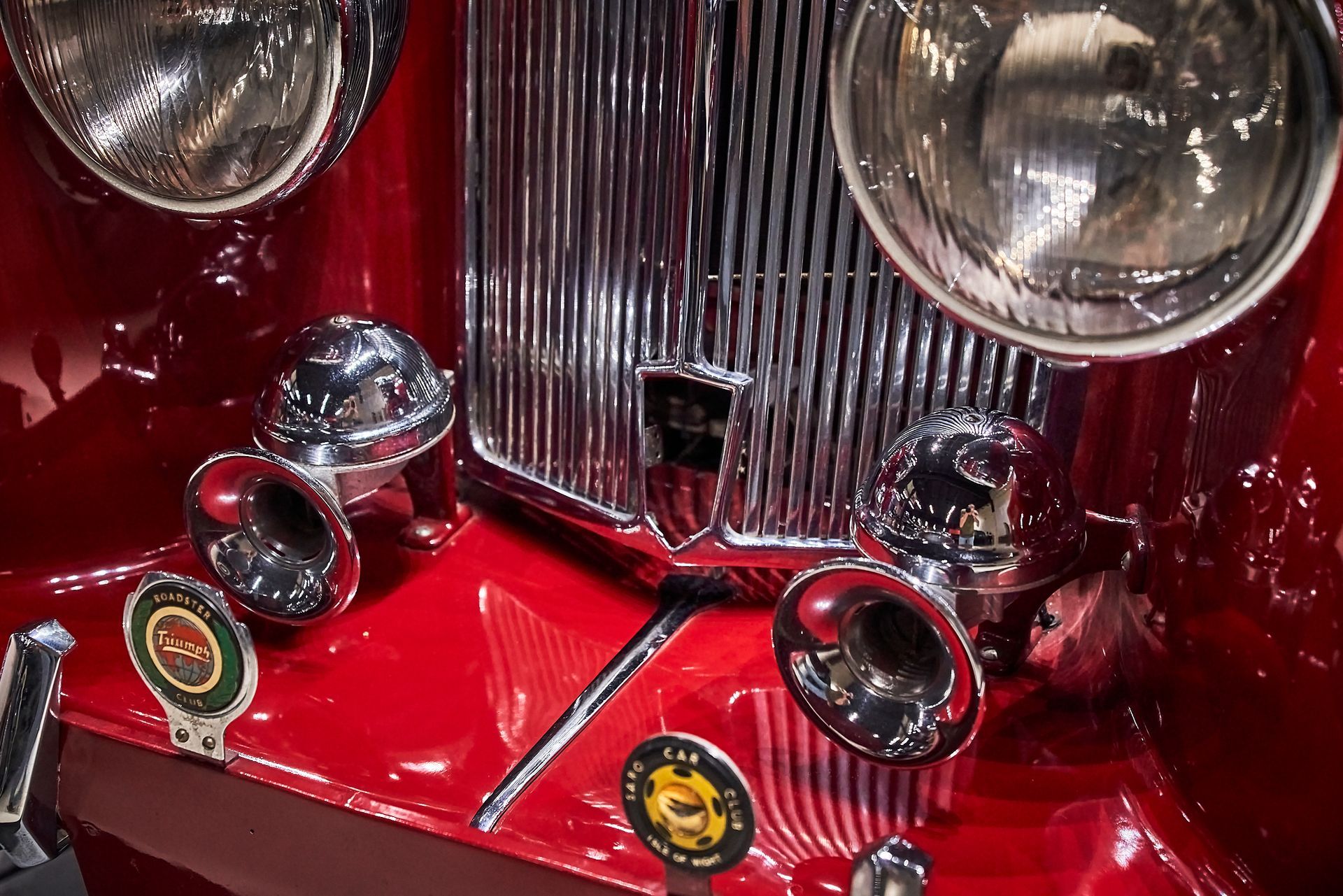 A close up of the front of an old red car