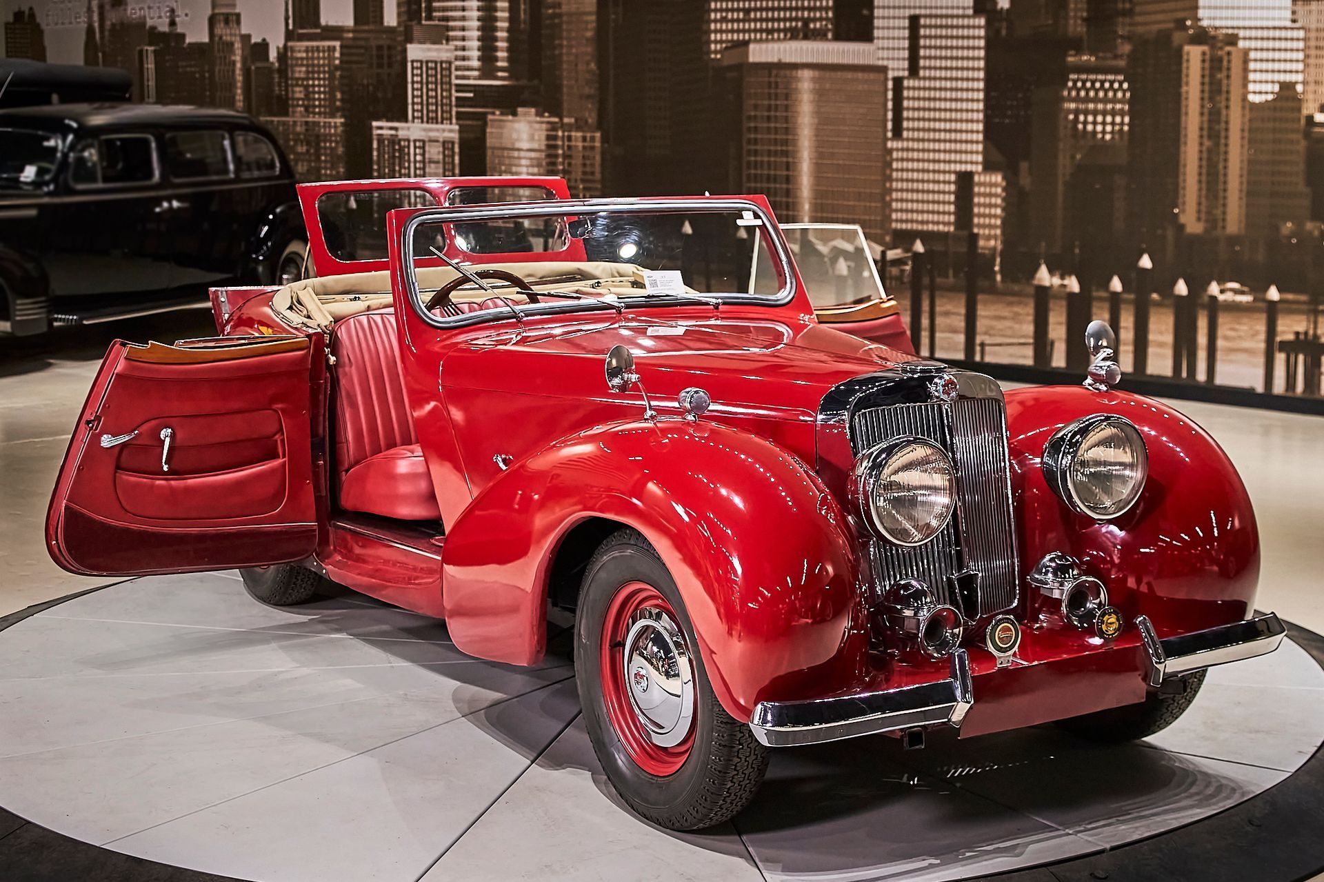 A red car with its doors open is on display