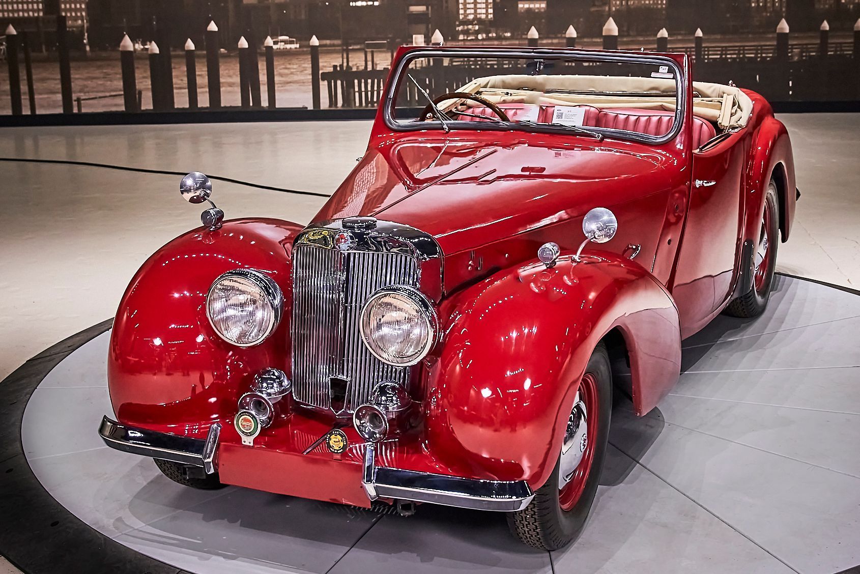 A red car is on display in a showroom