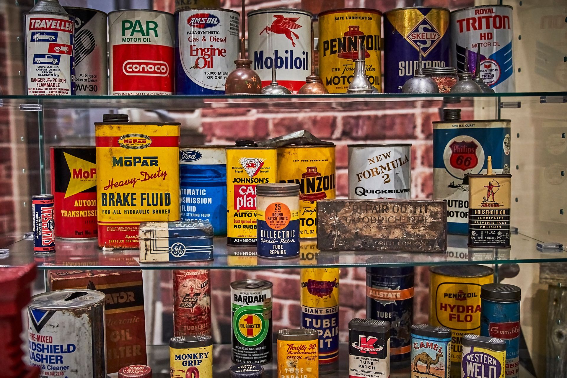 Classic Car Memorabilia - A display case filled with old cans of brake fluid