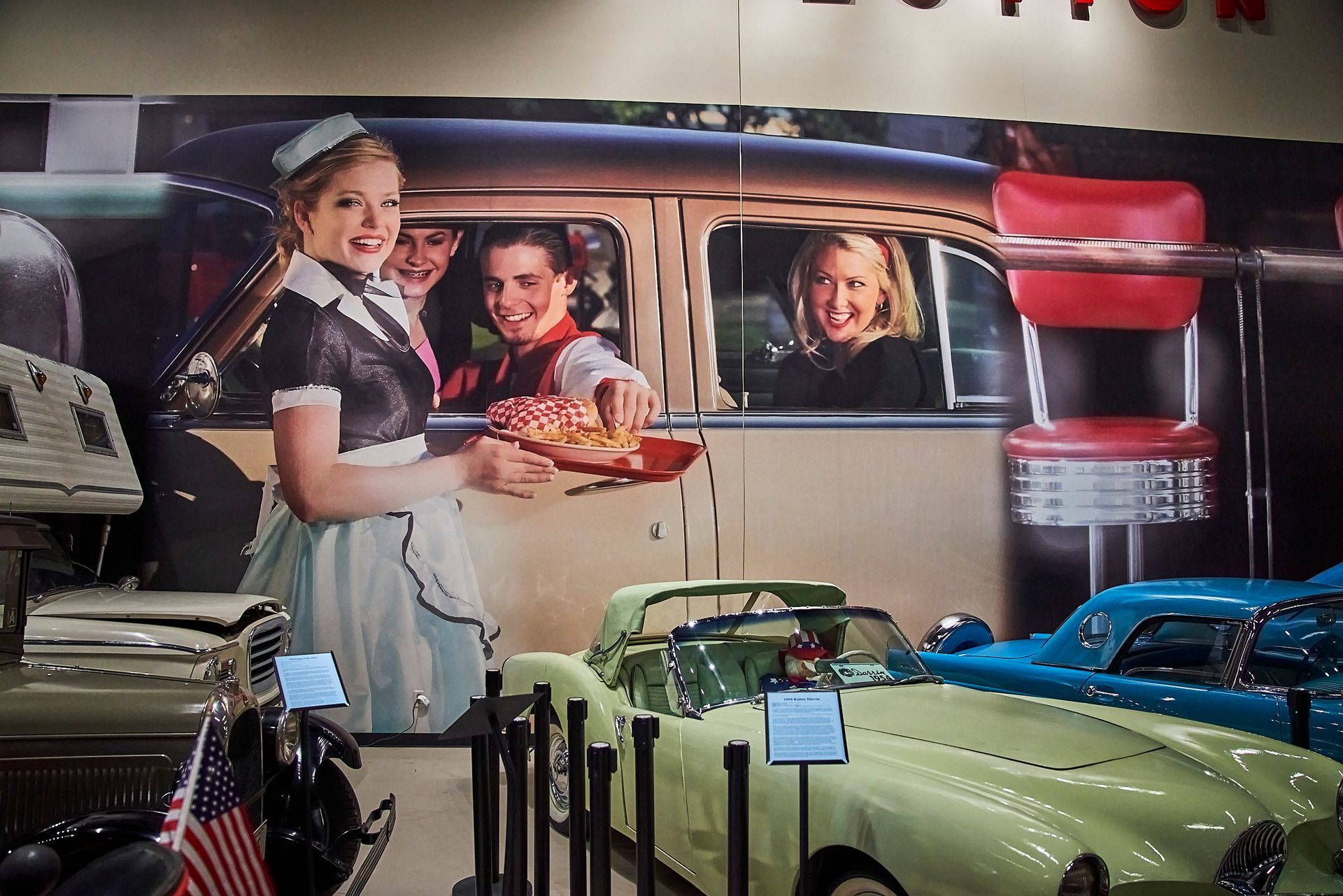 A picture of a waitress serving food to a family in a diner