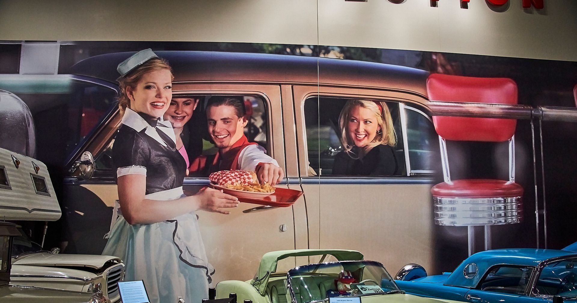 A waitress is serving food to a group of people in a diner.