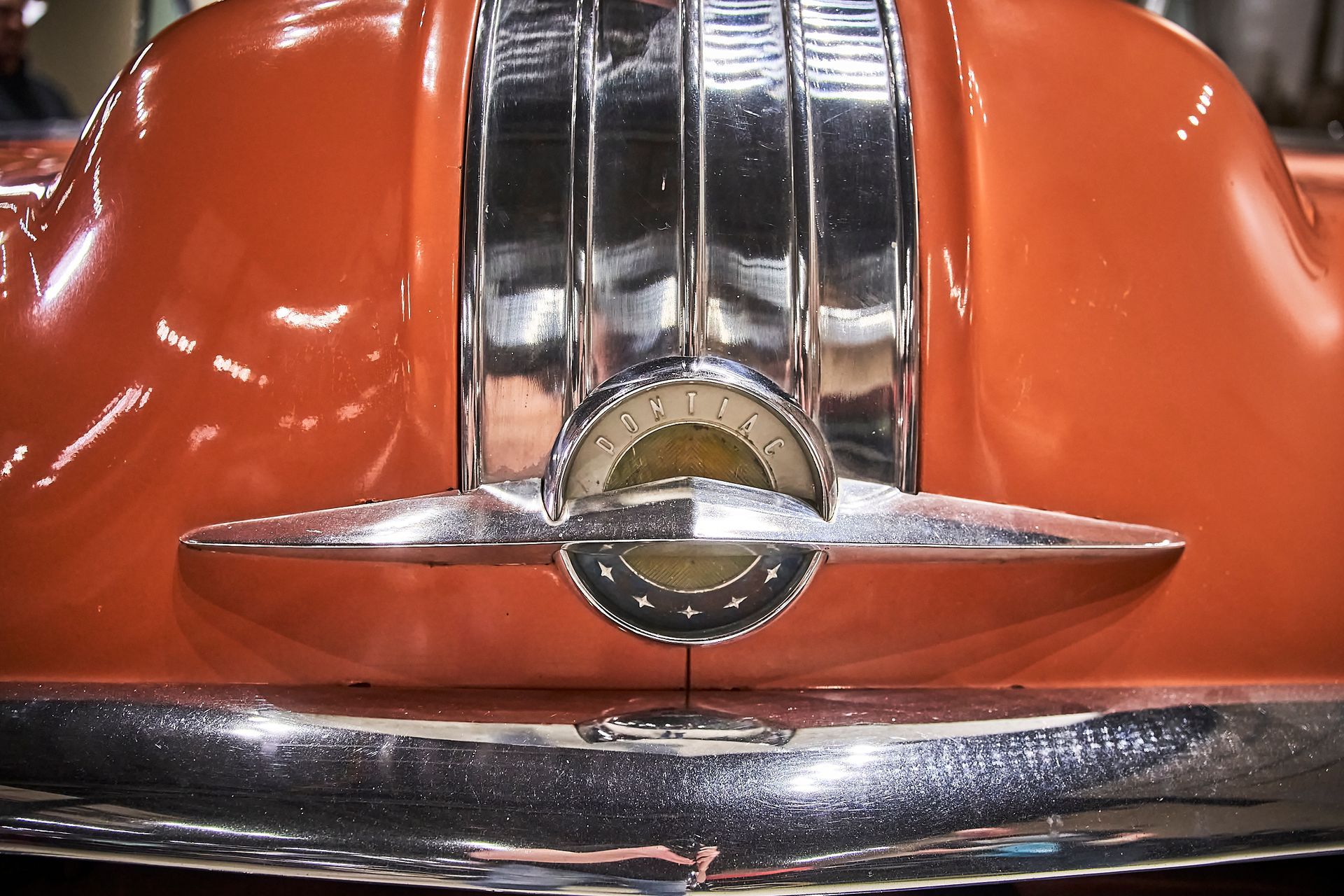 A close up of the front of an orange car