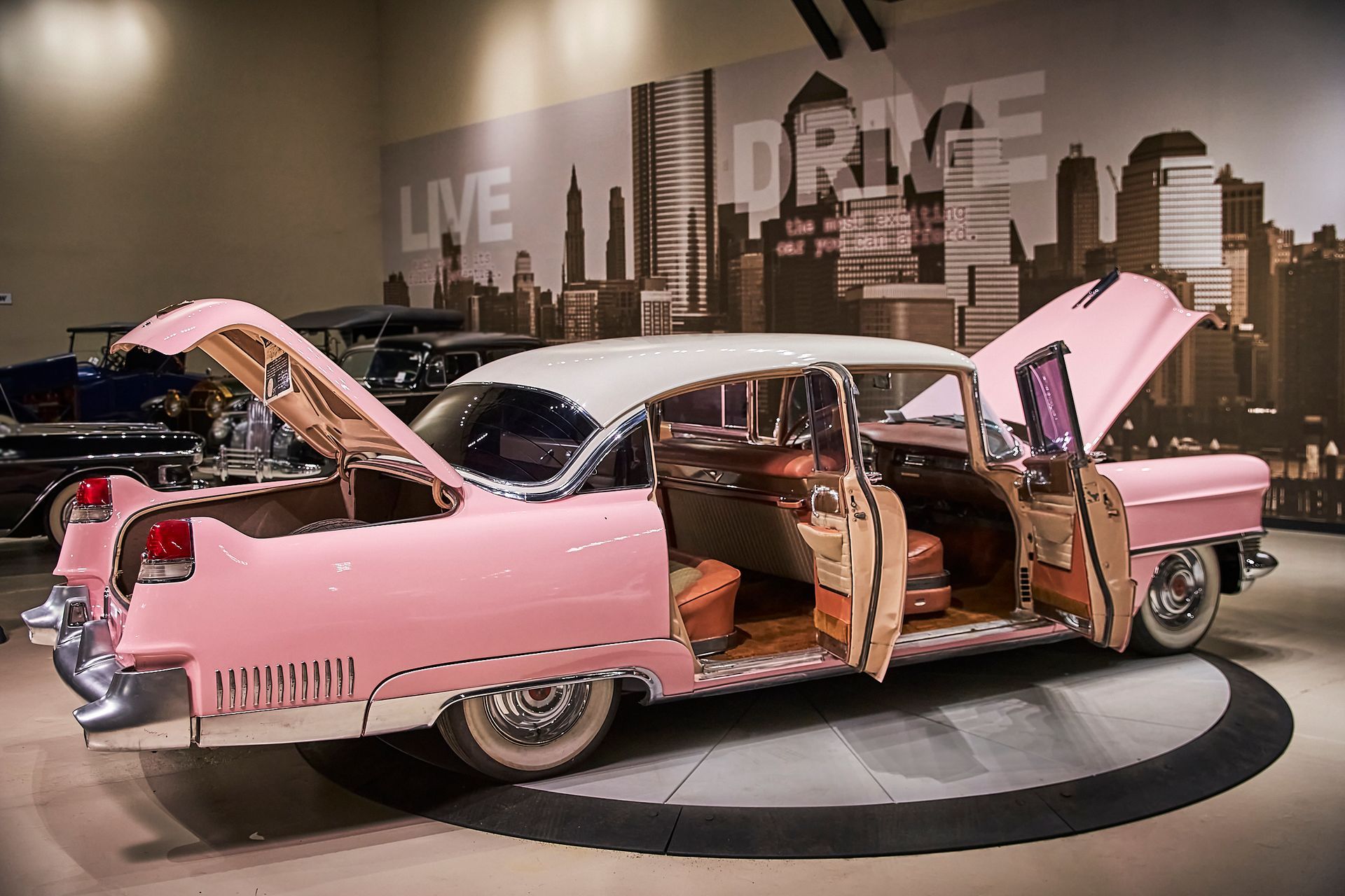 A pink and white car with the trunk open