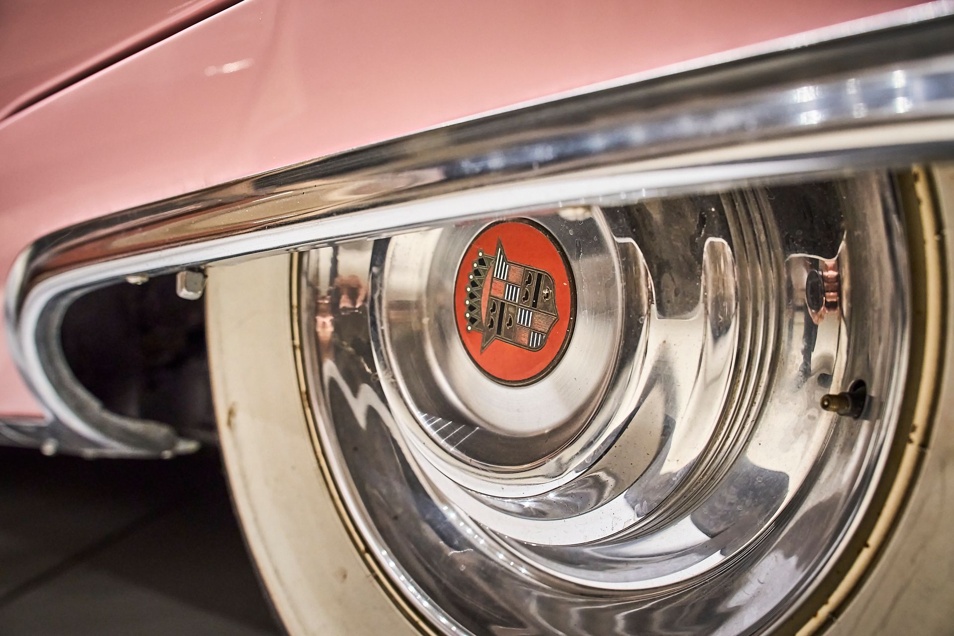 A close up of a wheel on a pink car.