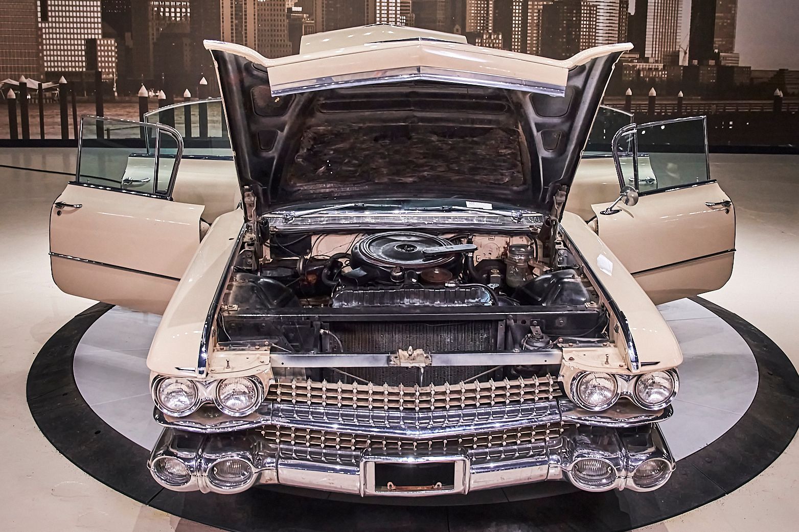 An old car with its hood open and its doors open