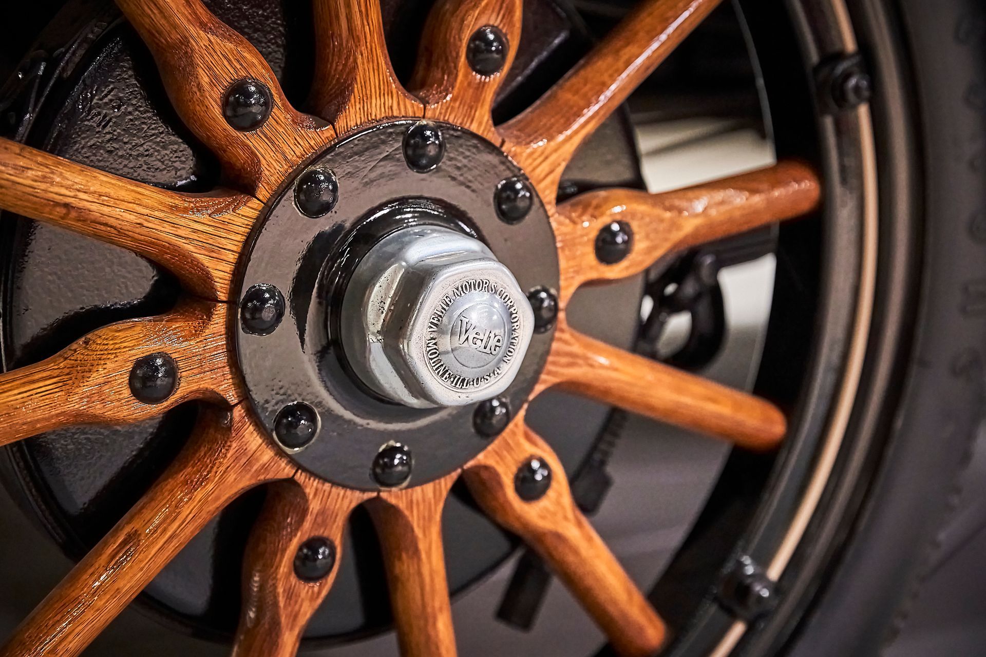 A close up of a wooden wheel on a car.