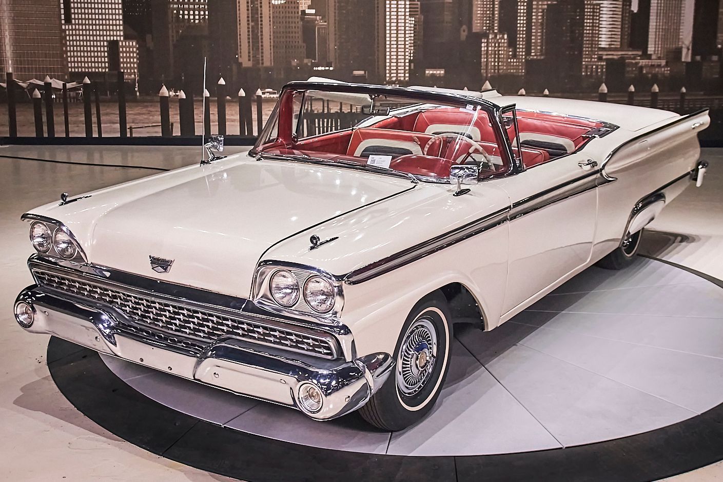 A white car with a red top is on display