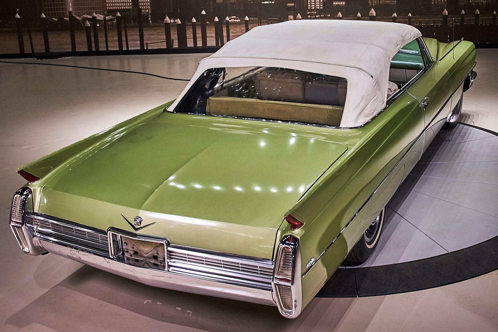 A green car with a white top is parked in a garage
