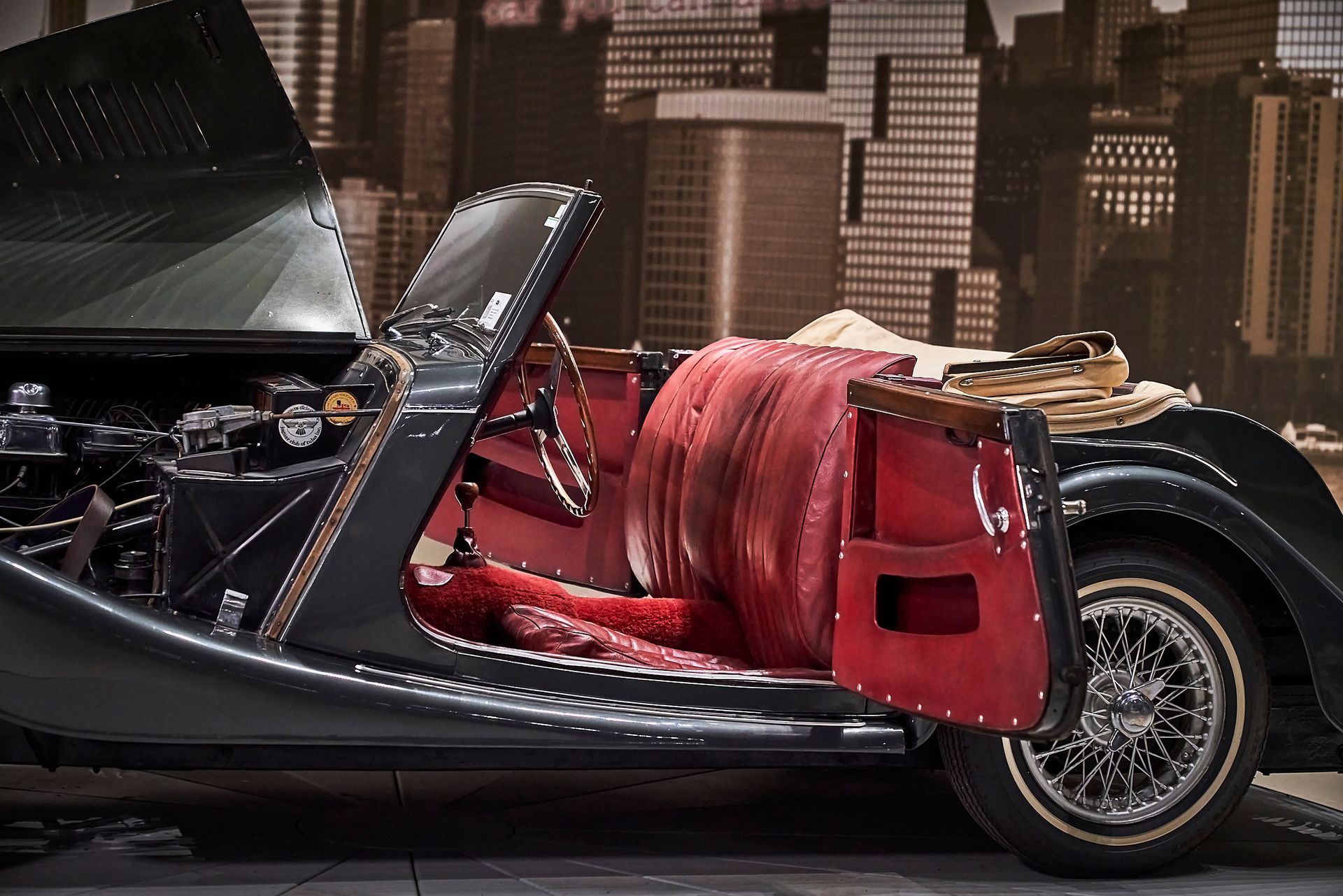 A black car with the hood open and red seats