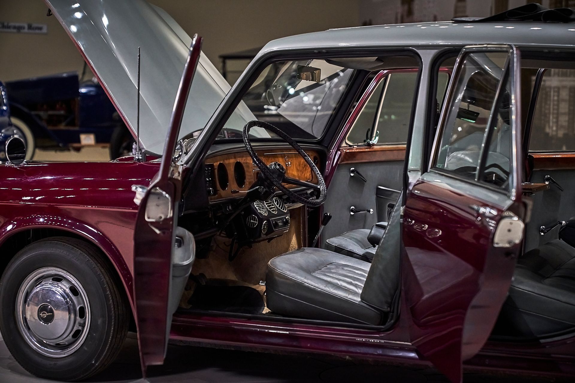 A red car with its doors open and the hood up.