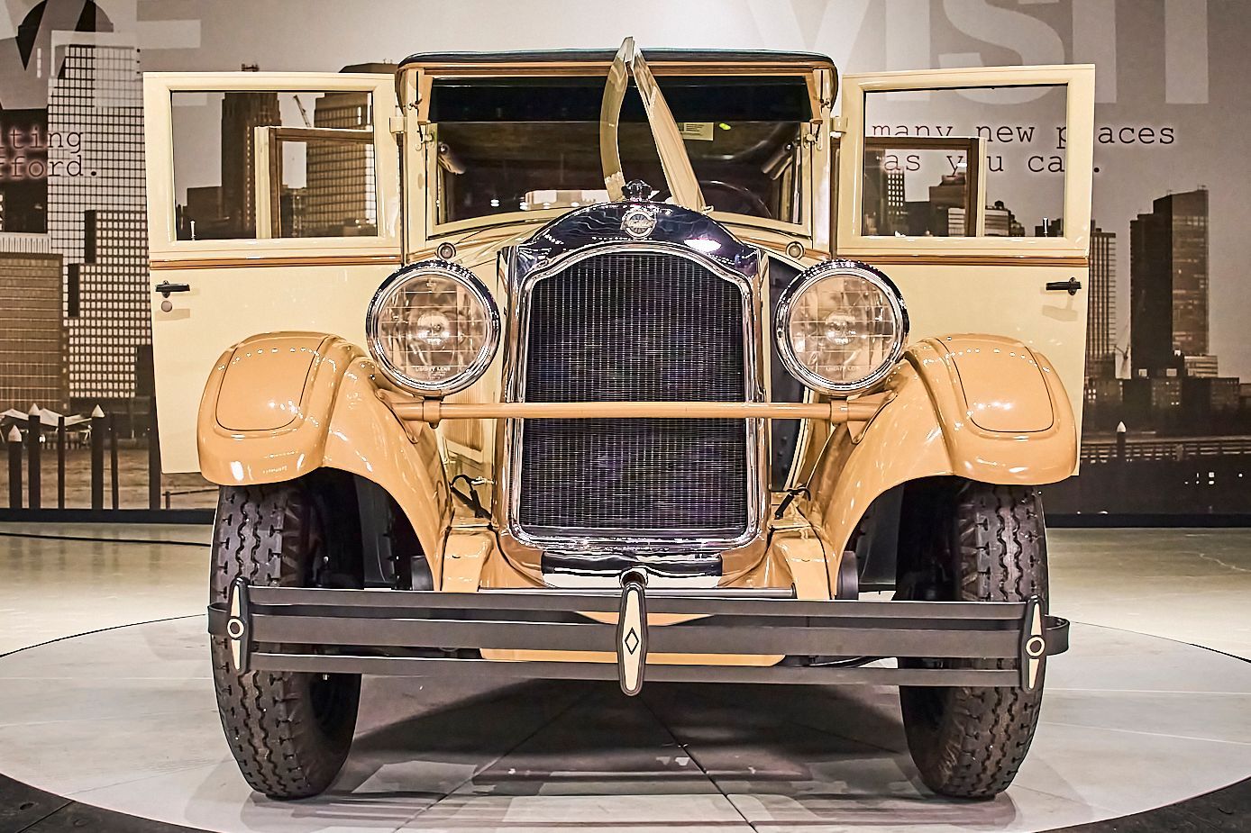 An old car is parked in a garage with its doors open.