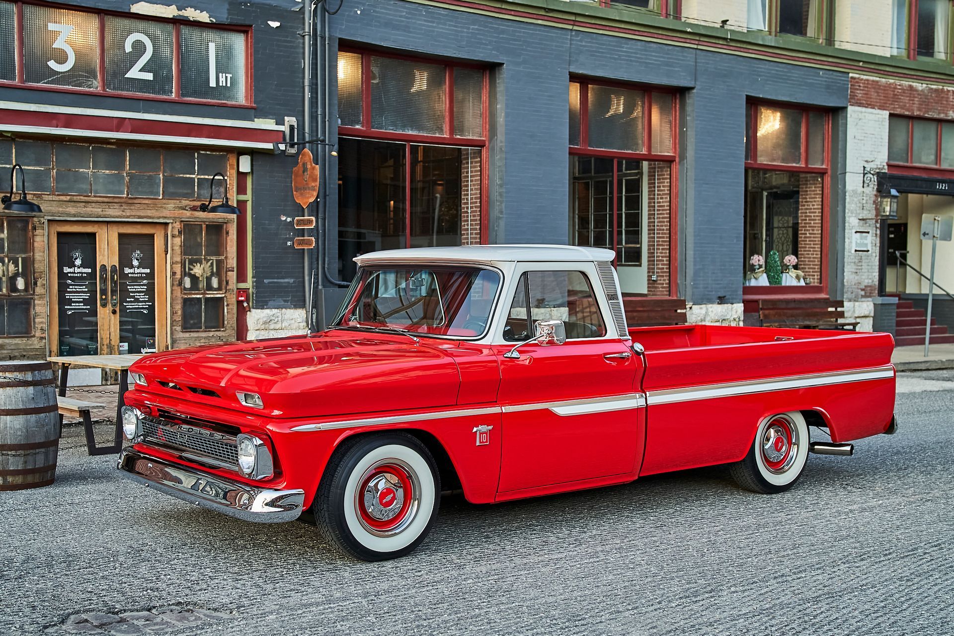 A red pickup truck is parked in front of a building.
