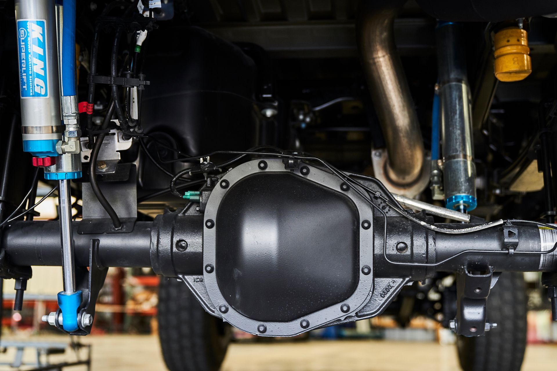 A close up of the underside of a truck 's rear axle.