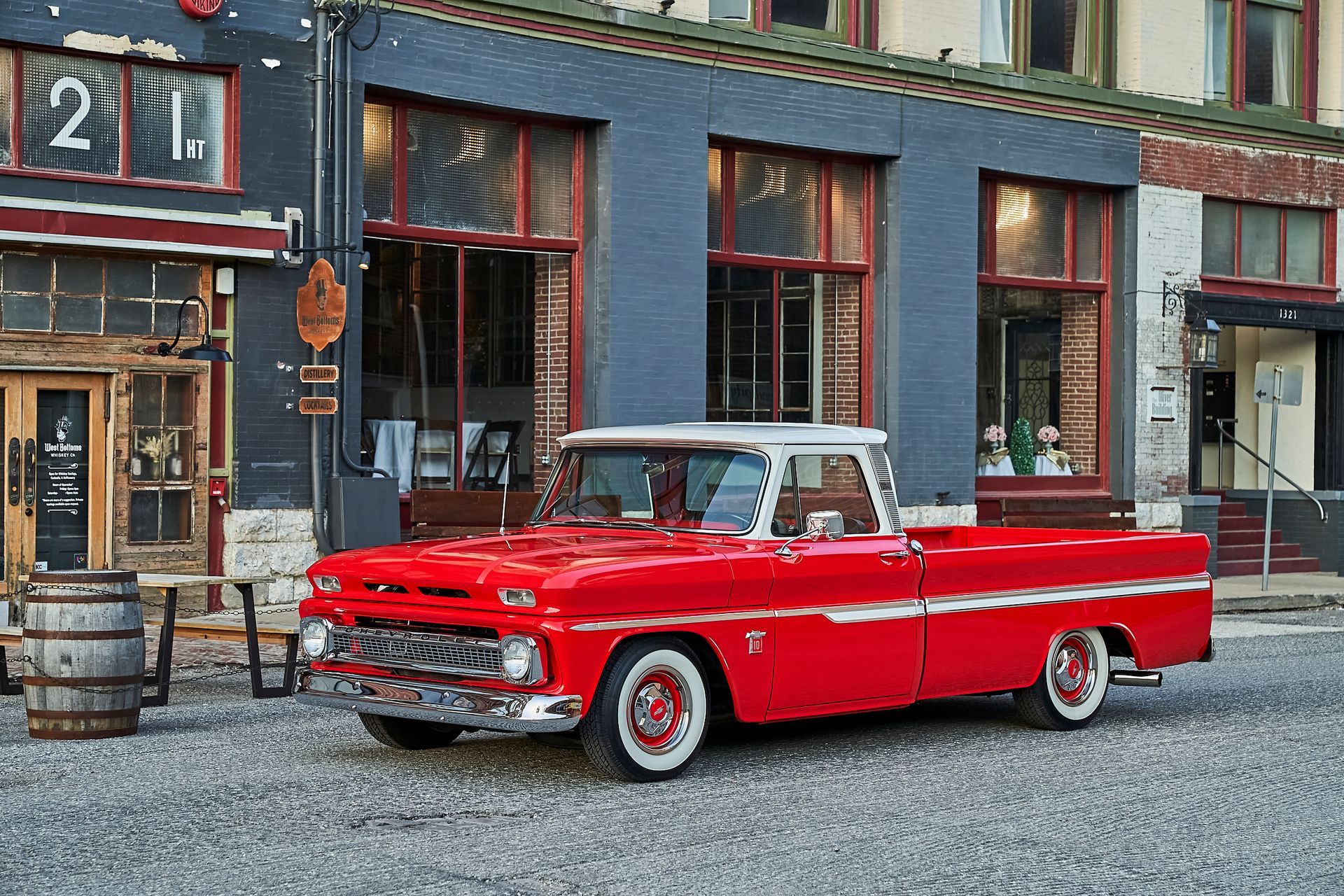 A red truck is parked in front of a building.