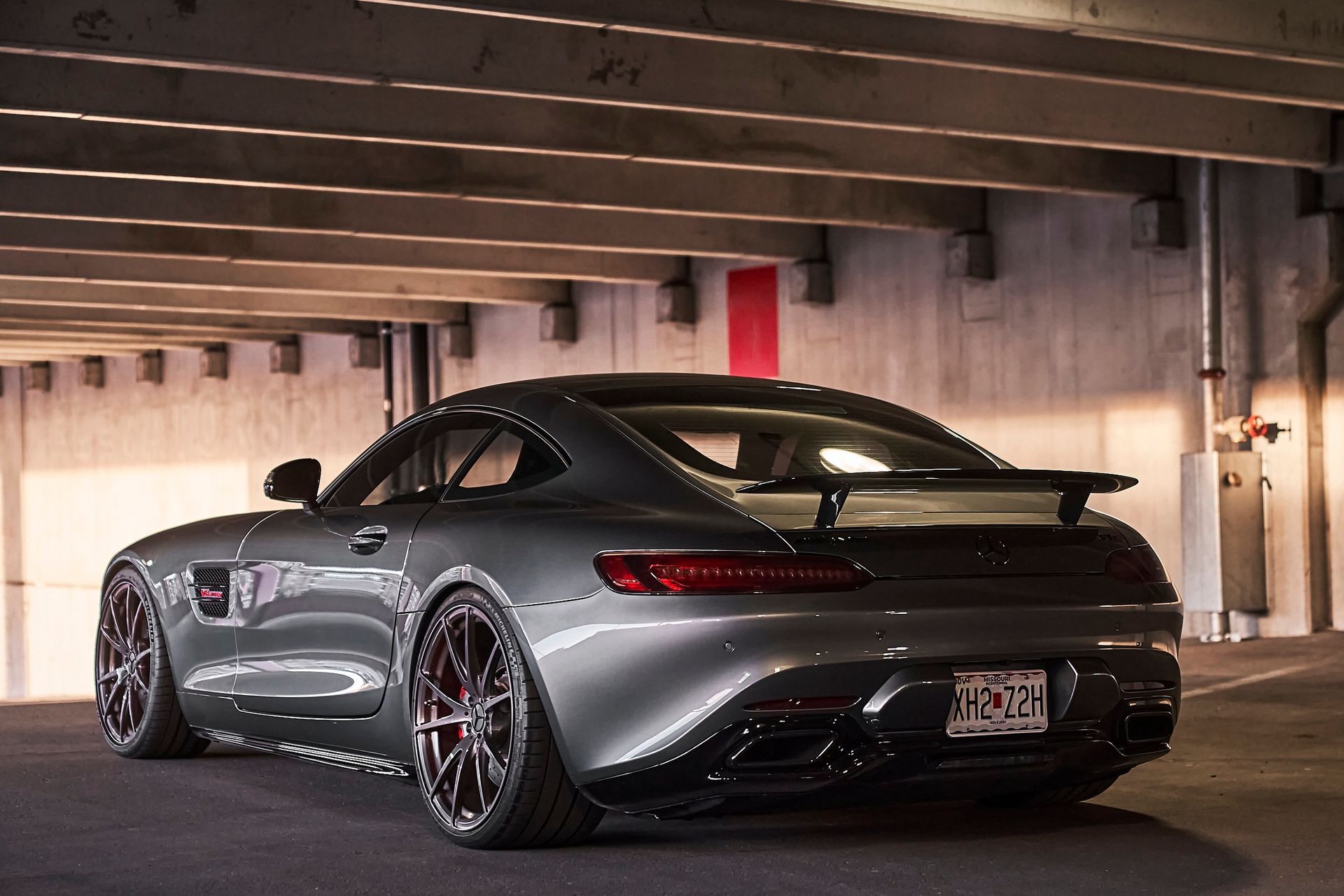 A gray sports car is parked in a parking garage.