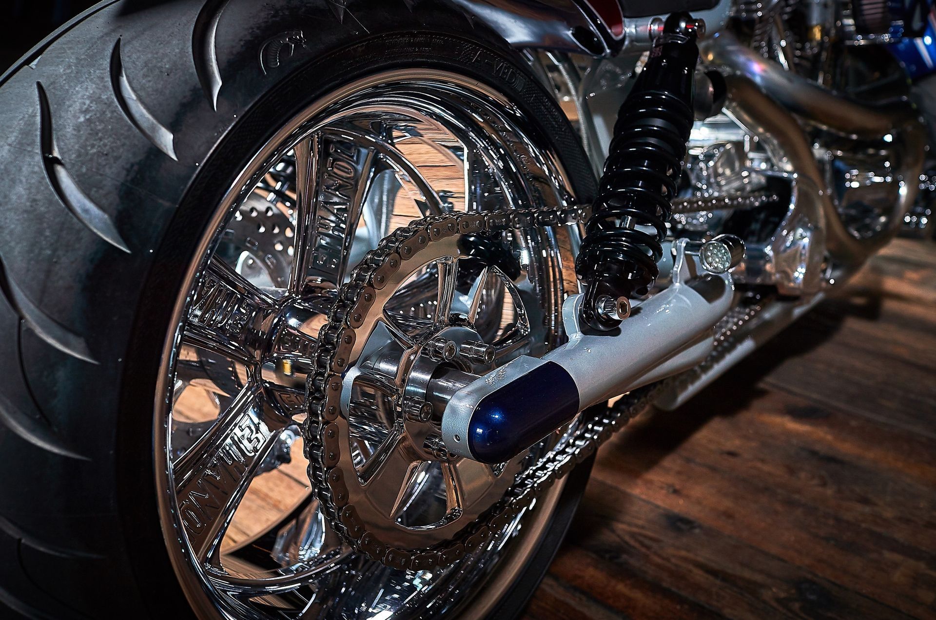 A close up of a motorcycle wheel on a wooden floor