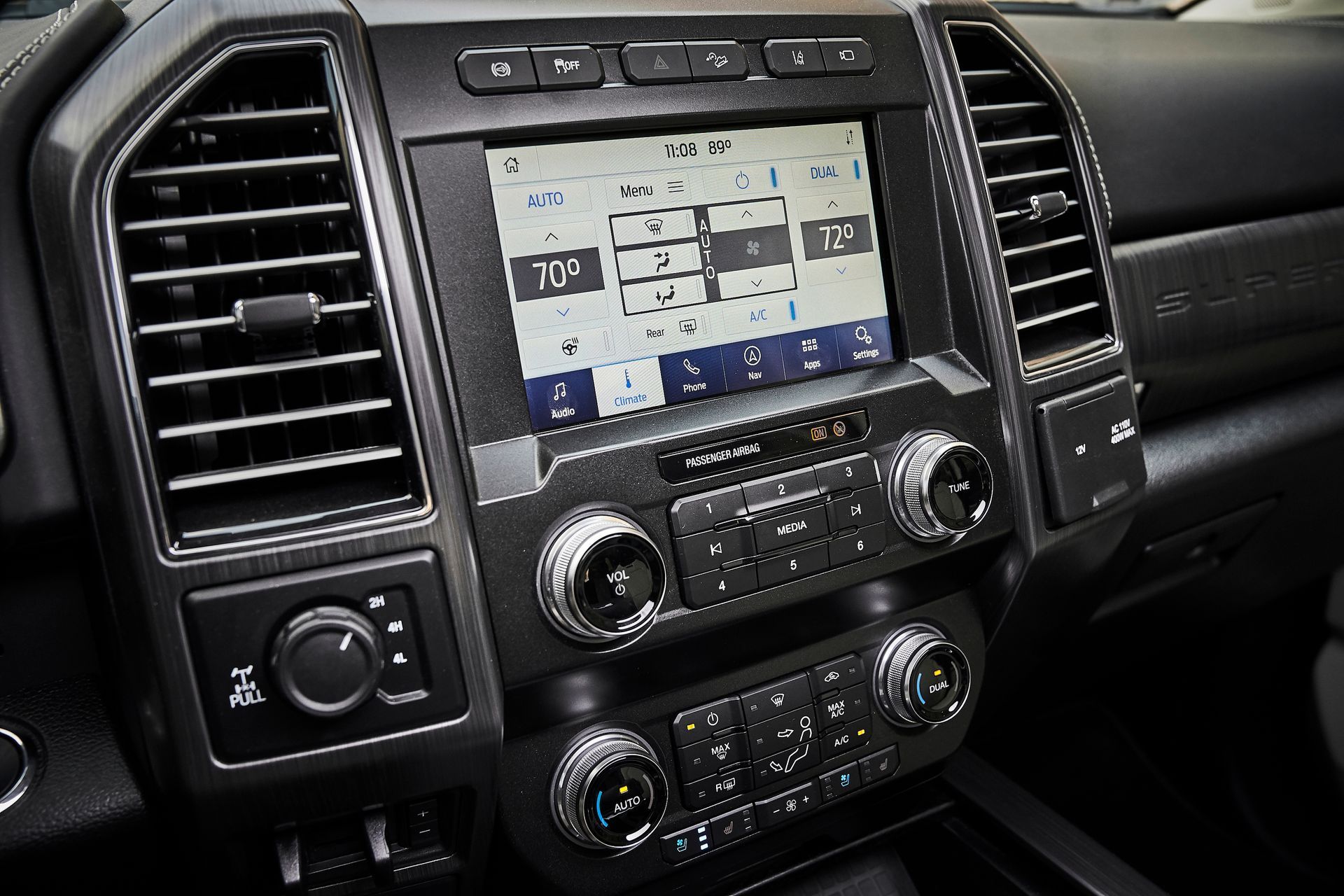 A close up of a car dashboard with a radio and air vents.